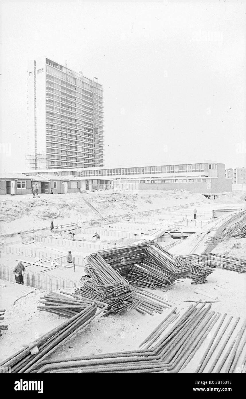 Activités Bouwes Palace Buildings Activities, Whizgle News, Dutch Desk, pays-Bas, 1950 - 2000 on 11-05-1965. Ces rubriques sont illustrées dans l'image. La scène représente un vaste chantier de construction sous une lumière vive et vive qui projette une qualité uniforme, presque éthéré sur le paysage. La palette monochromatique prédominante met en valeur les nuances de blanc et de gris, contribuant ainsi à un sentiment d’abstraction. Au premier plan, un arrangement chaotique de longs tuyaux en acier se trouve de manière désordonnée, leurs formes angulaires ajoutant un sentiment de désordre au milieu de l'environnement structuré. Ils sont disposés dans une tang Banque D'Images