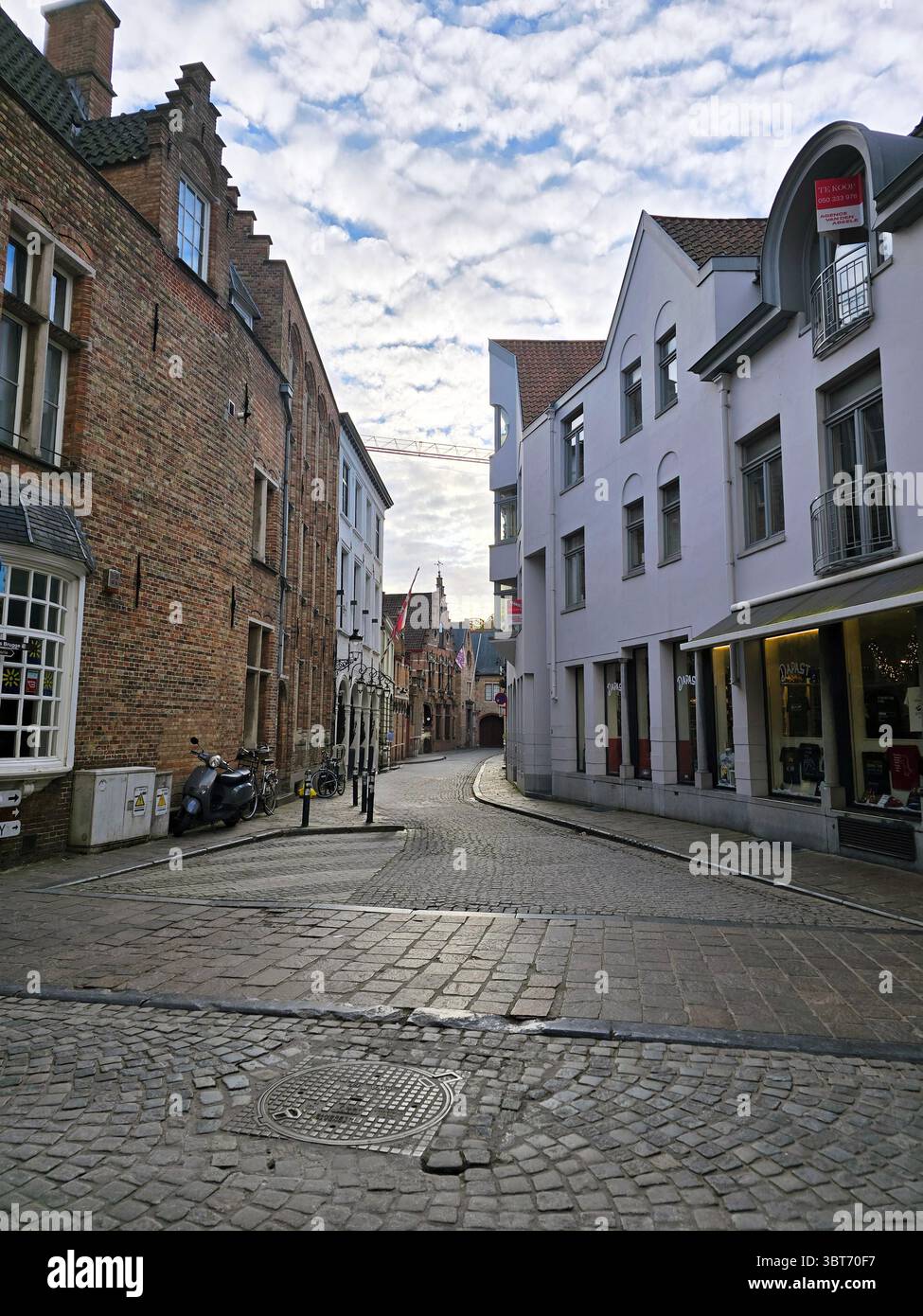 Scène paisible de canal à Bruges, en Belgique, encadrée par des arbres d'automne et des bâtiments historiques sous un ciel bleu spectaculaire. Banque D'Images Scène paisible de canal à Bruges, en Belgique, encadrée par des arbres d'automne et des bâtiments historiques sous un ciel bleu spectaculaire. Banque D'Images