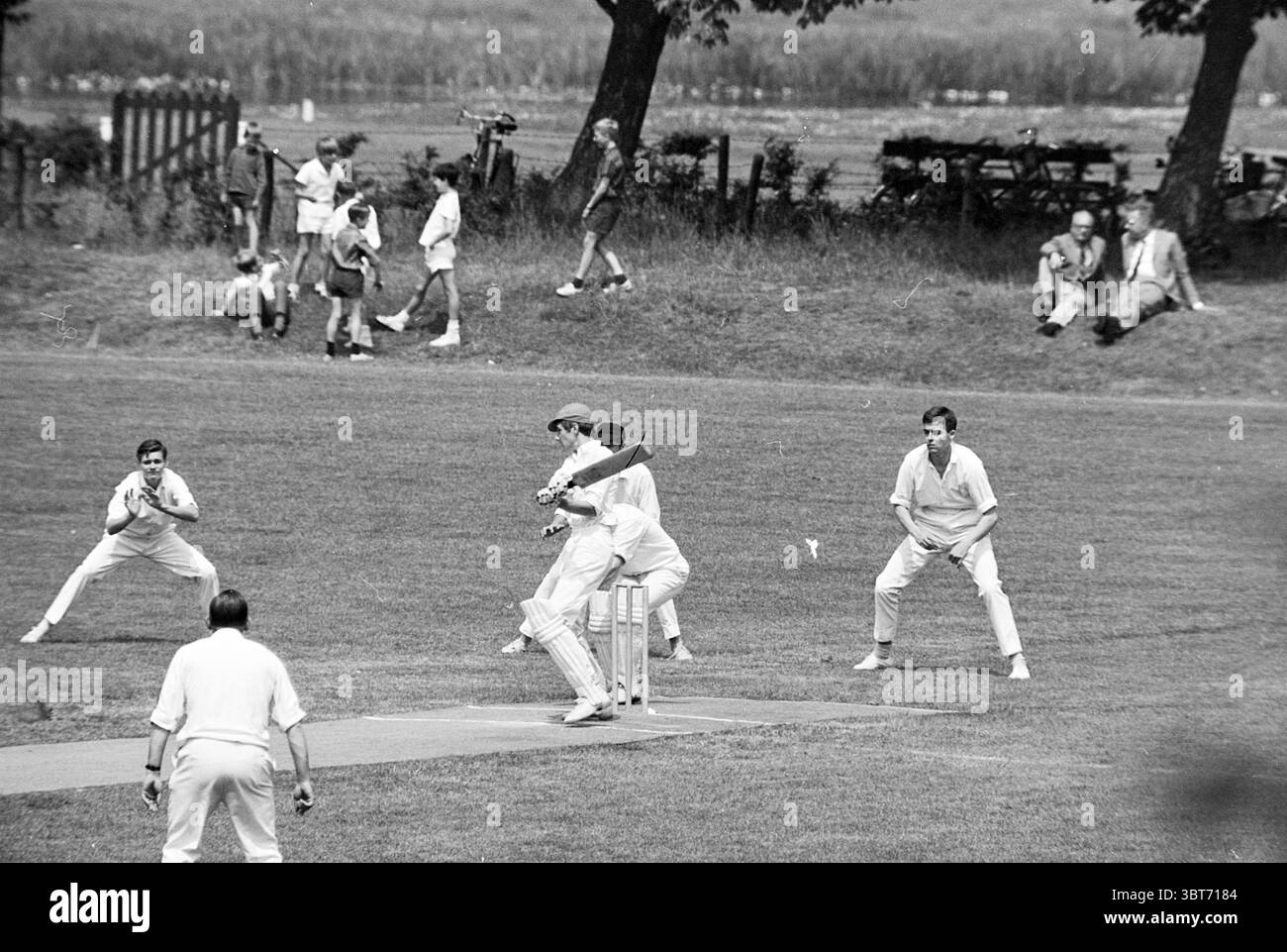 Haarlem - H.B.S. Cricket, Whizgle News, Dutch Desk, pays-Bas, 1950 - 2000 le 07-06-1965. L'image contient ces rubriques. La scène capture un match de cricket animé dans un cadre extérieur pittoresque. L'herbe verte éclatante recouvre le champ, créant un tapis luxuriant sous les pieds, tandis que les arbres bordent le périmètre, leurs feuilles bruissent légèrement dans la douce brise. Au premier plan, un batteur est pris en train de balancer sa batte, clairement concentrée et bien fixée, alors que la balle zoome vers lui. Vêtu de vêtements de cricket blancs traditionnels, la position du batteur respire la concentration et l'énergie. BE Banque D'Images Haarlem - H.B.S. Cricket, Whizgle News, Dutch Desk, pays-Bas, 1950 - 2000 le 07-06-1965. L'image contient ces rubriques. La scène capture un match de cricket animé dans un cadre extérieur pittoresque. L'herbe verte éclatante recouvre le champ, créant un tapis luxuriant sous les pieds, tandis que les arbres bordent le périmètre, leurs feuilles bruissent légèrement dans la douce brise. Au premier plan, un batteur est pris en train de balancer sa batte, clairement concentrée et bien fixée, alors que la balle zoome vers lui. Vêtu de vêtements de cricket blancs traditionnels, la position du batteur respire la concentration et l'énergie. BE Banque D'Images