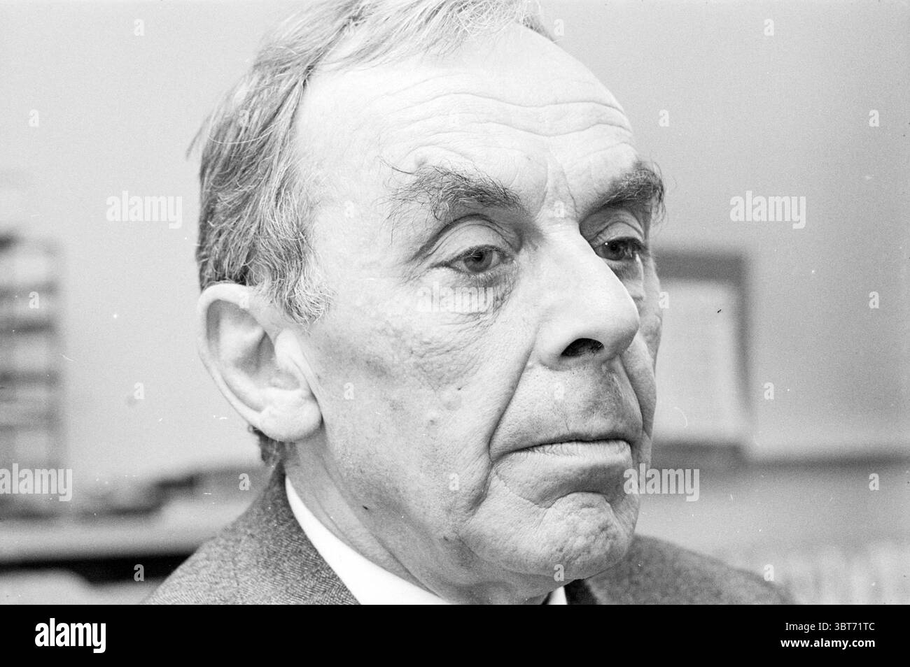 Portrait du professeur Wegener Schleswijk Amsterdam Portraits, Whizgle News, Dutch Desk, pays-Bas, 1950 - 2000 le 06-11-1969. Voici les rubriques de l'image. La scène montre un gros plan d'un homme plus âgé avec des traits faciaux distincts. Sa peau a une texture légèrement altérée, évoquant une vie riche en expériences. Ses cheveux de couleur claire, soigneusement peignés dans le dos, contrastent avec les tons foncés de sa veste de costume, qui semble bien taillée et formelle. L'expression de l'homme est sérieuse et contemplative, avec des sourcils fins et sillonnés qui ajoutent à la profondeur de son regard. Ses yeux, légèrement Banque D'Images
