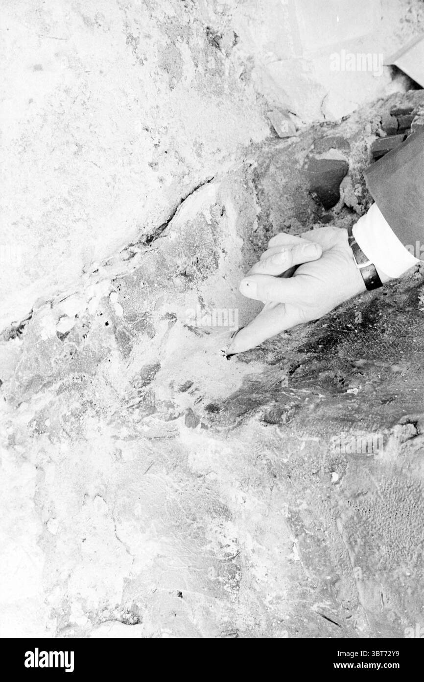 Fuite Dolfirama Dolfinarium, Whizgle News, Dutch Desk, pays-Bas, 1950 - 2000 le 04-09-1969. Ce sont les éléments de l'image. La scène représente une vue rapprochée d'une surface texturée qui semble être un mur, avec une main tendue vers lui. L'aiguille, ornée d'une montre, est positionnée délicatement, indiquant un examen minutieux de la surface. Le mur lui-même semble rugueux et inégal, avec des taches de différentes nuances de gris et des notes de blanc, suggérant un âge ou une usure possible. Il y a de petites fissures et crevasses visibles, ajoutant à la robustesse de la texture. Certaines zones peuvent avoir Banque D'Images