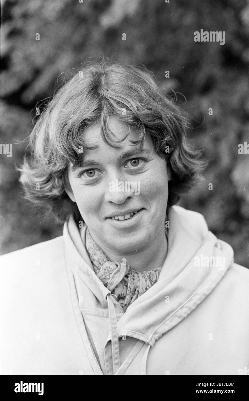 Portraits 6 personnes pour le Courier Portraits, Whizgle News, Dutch Desk, pays-Bas, 1950 - 2000 sur 08-10-1982. L'image montre ces rubriques. Dans la scène, une jeune femme est centrée, présentant une expression chaleureuse et accueillante. Ses cheveux sont courts, avec des vagues douces et naturelles, encadrant son visage doucement. Elle porte un vêtement ample de couleur claire qui contraste avec ses traits doux. L'arrière-plan est flou et composé de textures organiques, évoquant un cadre naturel, éventuellement à l'extérieur. L'éclairage est doux et diffus, illuminant son visage uniformément et soulignant subtilement ses traits, cr Banque D'Images