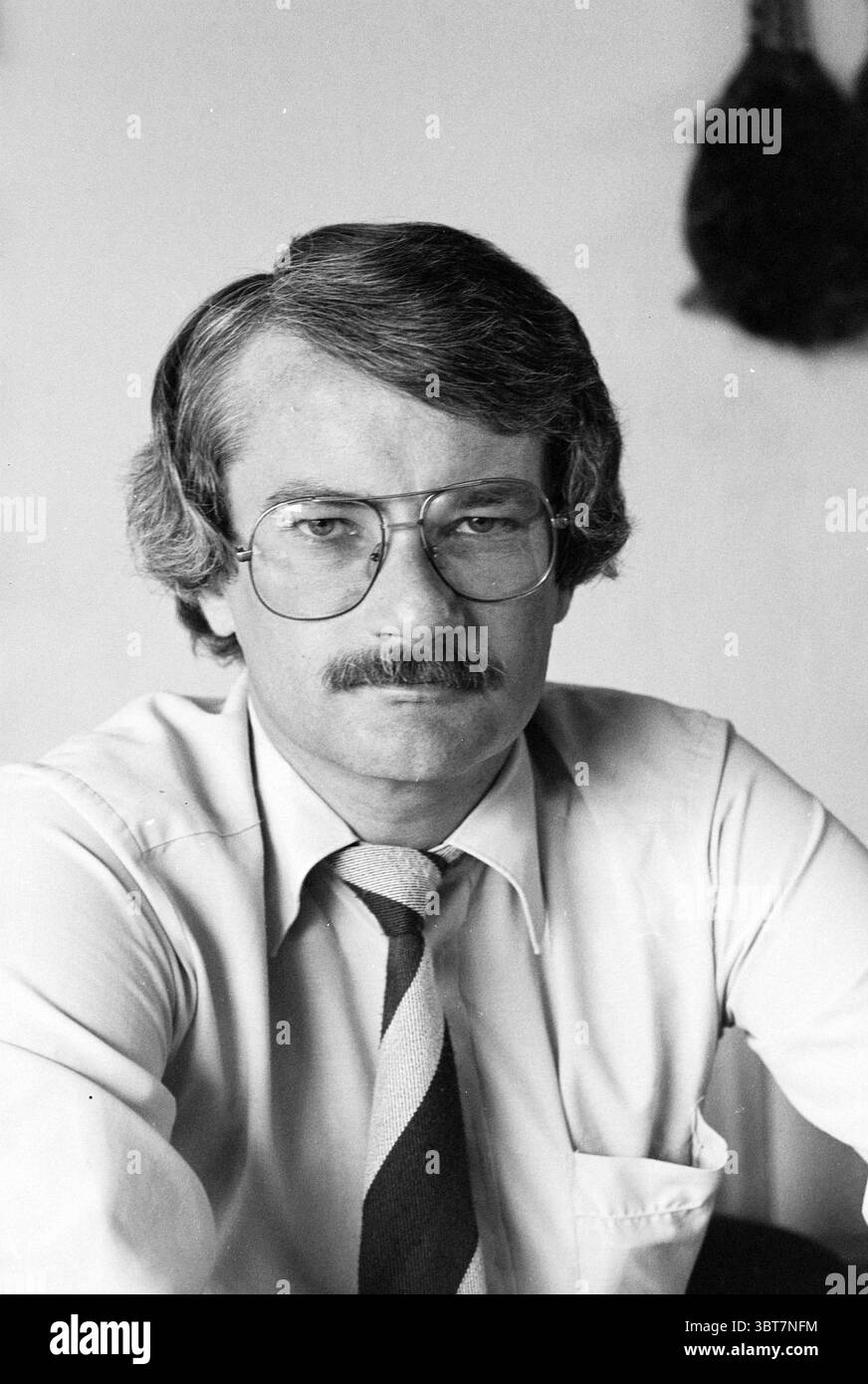 Michel Jager président de la VPRO et conseiller municipal de Heemstede pour D'66. Personnes. Télévision. Heemstede pays-Bas, Whizgle News, Dutch Desk, pays-Bas, 1950 - 2000 le 07-06-1980. L'image contient ces rubriques. Dans cette scène, la figure centrale est un homme avec une moustache bien soignée et des cheveux épais et stylés qui ont une texture légèrement ondulée. Il porte de grandes lunettes rectangulaires qui ajoutent une touche d'intellectualité à son apparence. Vêtu d'une chemise de couleur claire, le col est soigneusement pressé, donnant une impression de professionnalisme. Sa cravate présente un motif à rayures diagonales Banque D'Images