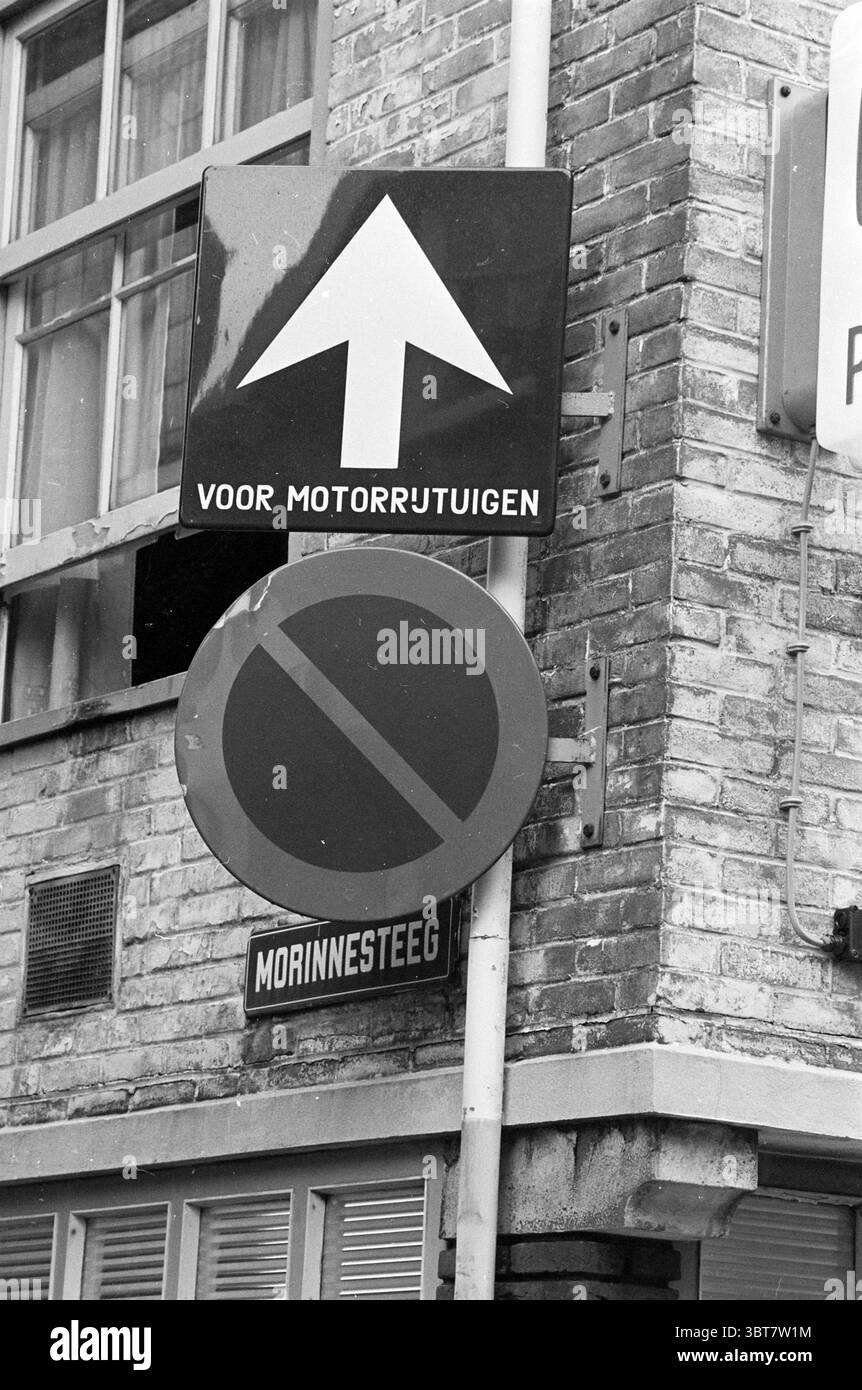 Panneaux de signalisation pour la circulation à sens unique et le stationnement interdit Morinnesteeg corner Smedestraat Haarlem Smedestraat pays-Bas., Whizgle News, Dutch Desk, pays-Bas, 1950 - 2000. Ce sont les éléments de l'image. La scène présente une combinaison de panneaux de signalisation montés sur un poteau vertical, positionnés contre un mur de briques qui affiche une surface rugueuse et texturée. Le signe supérieur comporte une flèche en gras pointant vers le haut, suggérant la direction. Son schéma de couleurs comprend un fond lumineux, probablement blanc, contrastant fortement avec la flèche noire, transmettant la clarté dans l'instruction. En dessous, un autre Banque D'Images
