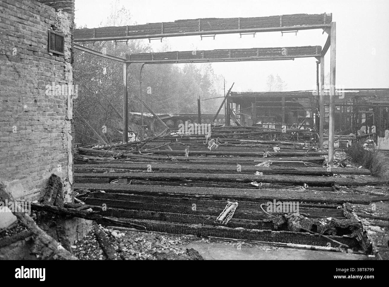 Rubbles Haarlemmermeer Lyceum Rubble, Whizgle News, Dutch Desk, pays-Bas, 1950 - 2000 le 02-01-1973. Ces rubriques sont illustrées dans l'image. La scène présente un paysage industriel dévasté, caractérisé par les restes d'un bâtiment autrefois structuré, maintenant réduit en restes carbonisés. Le premier plan présente un tapis de poutres en bois noircies et de débris, formant un motif chaotique contre l'environnement autrement sombre. Les couleurs sont dominées par des nuances de gris et de noir, avec des notes de brun de bois brûlé. L'atmosphère est lourde et sombre, évoquant un sentiment de perte et de désolation. Banque D'Images