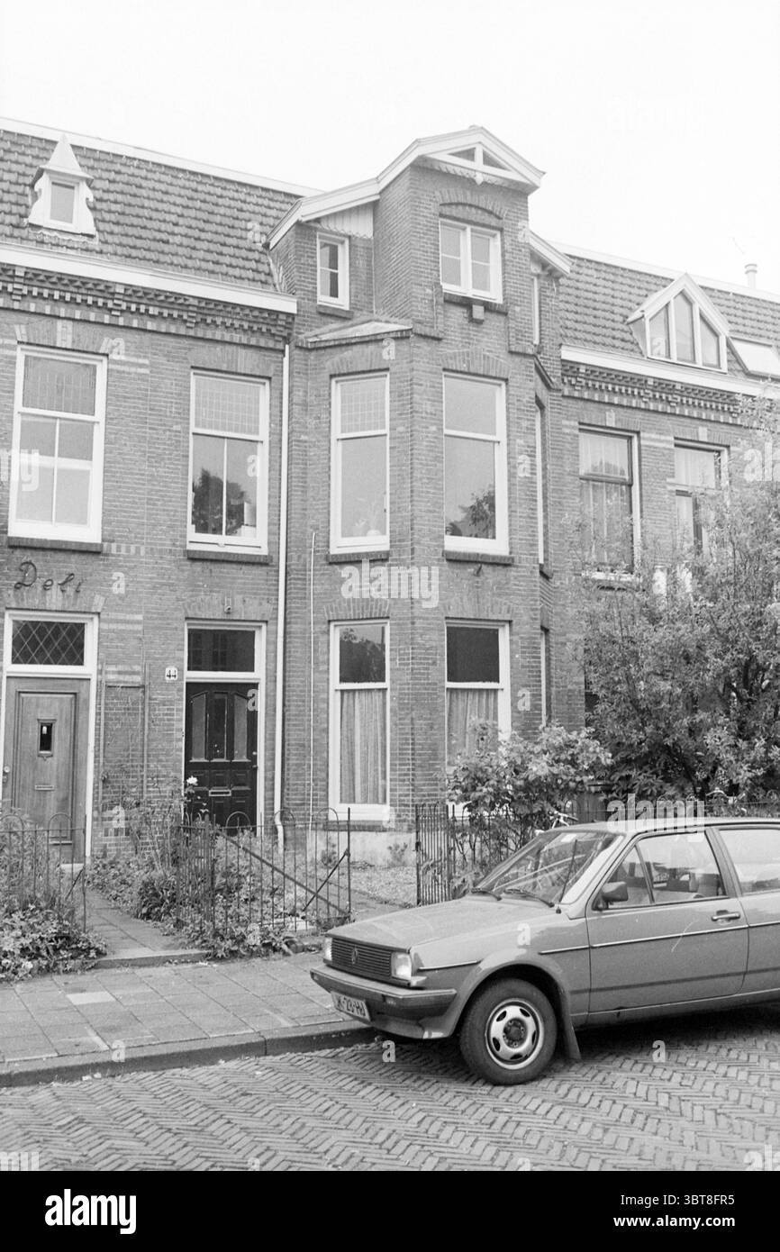 Ext. Maison Verspronckweg Haarlem Verspronckweg pays-Bas, Whizgle News, Dutch Desk, pays-Bas, 1950 - 2000 le 04-06-1992. Voici les rubriques de l'image. La scène présente un bâtiment résidentiel pittoresque caractérisé par sa façade haute et étroite construite à partir de briques rouges. L'architecture présente plusieurs toits à pignons, avec des pics proéminents et des détails complexes comme des cadres de fenêtres en bois, qui accentuent le charme vintage. Au premier plan, une automobile modeste mais élégante dans une nuance discrète de rouge-grisâtre repose le long d'une rue pavée, faisant allusion à une époque révolue. Son arrondi Banque D'Images