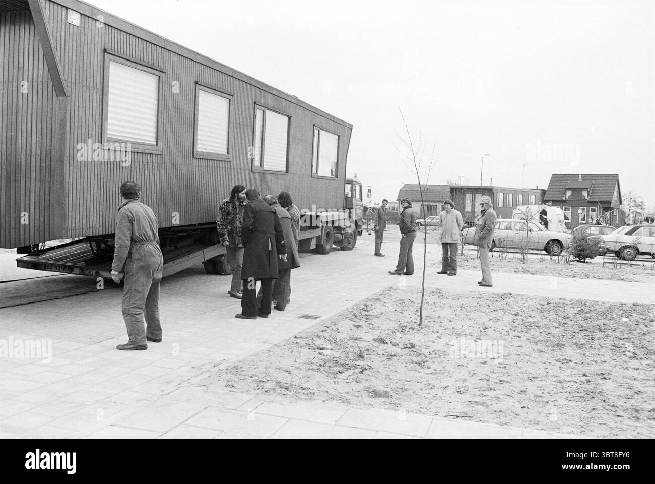 Ouverture du camp de caravanes Elzenhof Heemskerk ouverture ouvertures mise en service caravanes camps de caravanes résidents de caravanes Heemskerk, Whizgle News, Dutch Desk, pays-Bas, 1950 - 2000 on 07-05-1979. Ces rubriques sont illustrées dans l'image. Dans un environnement urbain animé, un groupe d'individus est rassemblé autour d'une grande structure transportée par camion. La scène met en valeur un contraste saisissant entre l'extérieur en bois du bâtiment et l'environnement environnant. Les personnes présentes affichent un mélange d’expressions, incarnant la curiosité et l’anticipation. Certains sont activement engagés dans l'aide à Banque D'Images