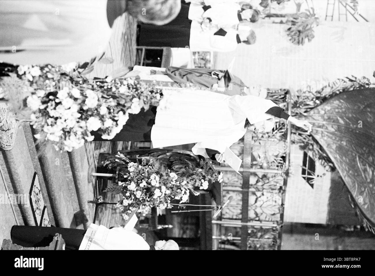 Ordination de l'évêque Bomers et de l'évêque auxiliaire Lescrauwaert RK Bavo Haarlem consécration Église catholique romaine Haarlem pays-Bas, Whizgle News, Dutch Desk, pays-Bas, 1950 - 2000 on 14-01-1984. Voici les rubriques de l'image. La scène représente une cérémonie religieuse solennelle qui a lieu à l'intérieur. À l'avant-garde, une personne vêtue d'une robe blanche fluide avec une ceinture sombre se tient en évidence. Ils sont engagés dans un geste rituel, possiblement élevant un calice ou menant une bénédiction, véhiculant un sentiment de vénération et d'importance. Autour d'eux sont d'autres individus dans similaire Banque D'Images