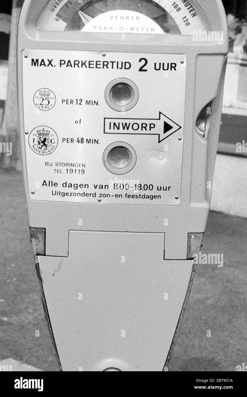 Parcmètre dans IJmuiden parking parkings parkings parkings IJmuiden pays-Bas, Whizgle News, Dutch Desk, pays-Bas, 1950 - 2000 on 15-03-1984. Ces rubriques apparaissent dans l'image. La scène présente un parcmètre, principalement dans un ton gris, transmettant un sentiment de fonctionnalité utilitaire. Sa surface semble quelque peu vieillie, avec de subtils signes d'usure qui font allusion à une utilisation à long terme. La conception est conforme aux parcomètres traditionnels, présentant un cadran circulaire en haut, marqué avec divers incréments de temps et les frais associés. La palette de couleurs globale est muette, principalement des nuances Banque D'Images