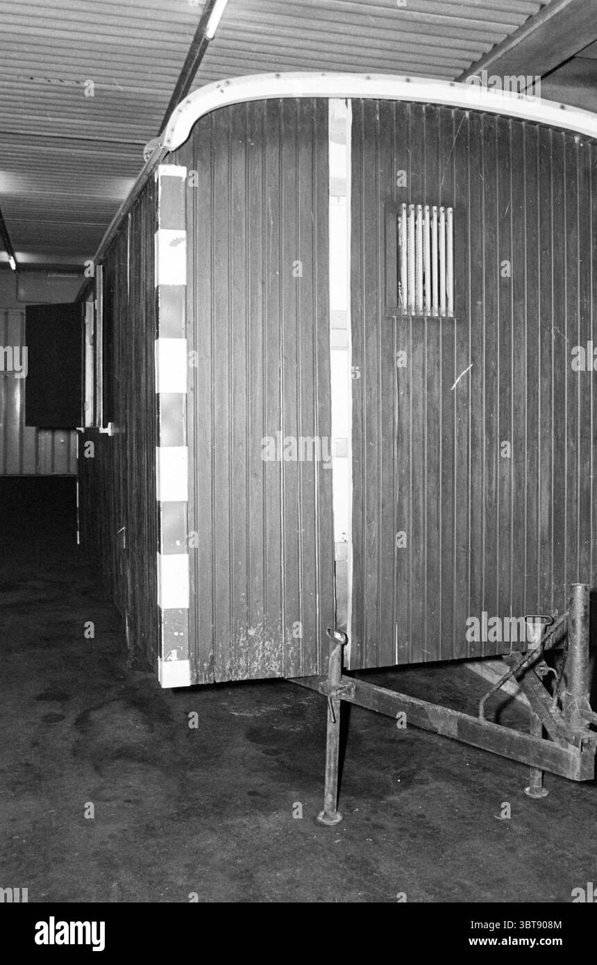 Coup de foudre dans une conduite d'eau de chantier, Whizgle News, Dutch Desk, pays-Bas, 1950 - 2000 on 15-10-1982. Ces rubriques apparaissent dans l'image. La scène présente une remorque en bois, caractérisée par ses planches sombres et altérées, qui affichent un charme rustique à travers diverses nuances de brun et des notes de gris. La structure semble être quelque peu vieillie, avec une usure apparente suggérant des années d'utilisation. Une petite fenêtre rectangulaire, barrée de fines lattes, ajoute une touche de détail sur le côté, permettant un aperçu de l'intérieur, bien que la vue soit obscurcie. Le réglage est à l'intérieur, Banque D'Images
