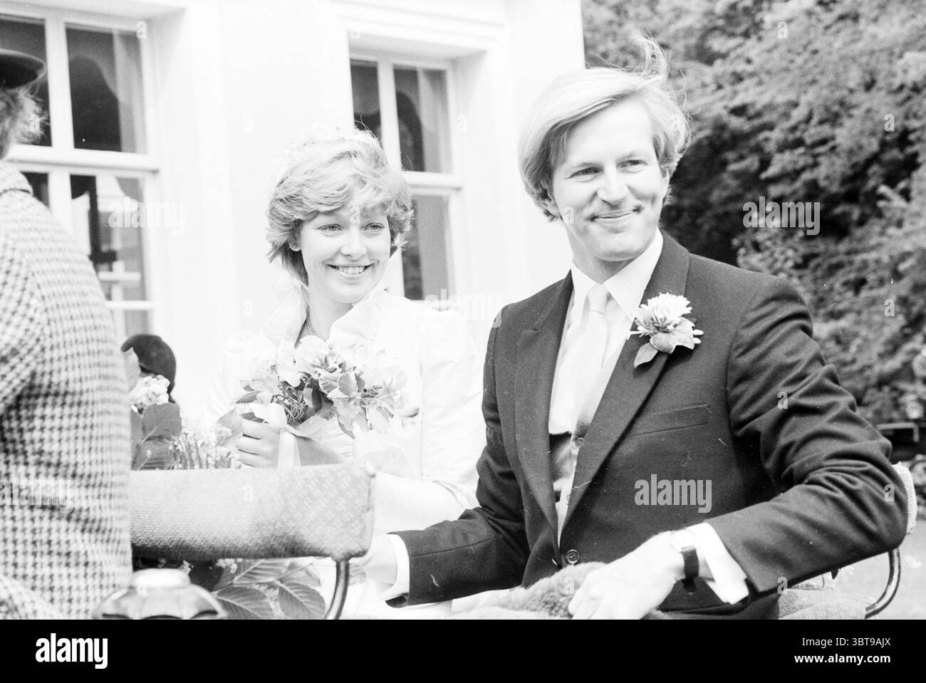 Calèches pour mariés Overveen Wedding Overveen, Whizgle News, Dutch Desk, pays-Bas, 1950 - 2000 on 20-06-1980. Ce sont les éléments de l'image. Dans un cadre extérieur serein, un couple respire la joie et la célébration. La femme, vêtue d'une robe de mariée classique ornée de dentelle délicate et de détails complexes, a des cheveux doux et fluides complétés par une coiffure florale. Elle tient un petit bouquet de fleurs, leurs couleurs chaleureuses et invitantes, ce qui ajoute au sentiment général de fête. À côté d'elle, un homme dans un costume bien taillé avec un éclat subtil, présente un shir de couleur claire Banque D'Images