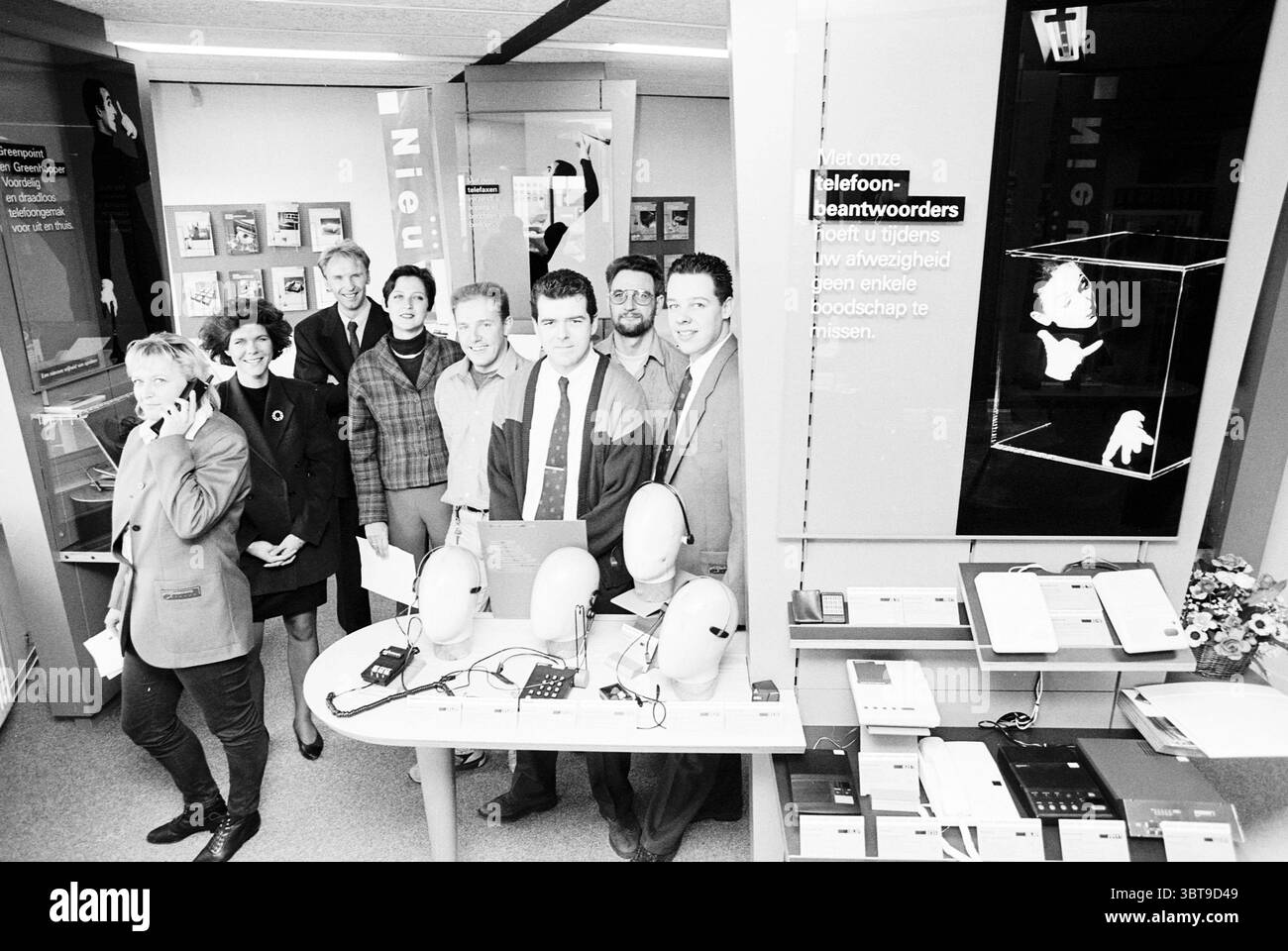 Dépassement de prix PTT-Alkmaar. Alkmaar, Whizgle News, Dutch Desk, pays-Bas, 1950 - 2000 le 01-03-1995. Voici les rubriques de l'image. Dans un espace commercial moderne, un groupe de huit personnes se réunit, créant un sentiment de camaraderie et de collaboration. Ils sont disposés en demi-cercle, avec un mélange d'hommes et de femmes. Les individus sont habillés dans une variété de styles, présentant un spectre de couleurs allant des tons discrets aux nuances plus vibrantes, ce qui ajoute un intérêt visuel. Le paramètre comporte plusieurs surfaces d'affichage, mettant en évidence divers appareils électroniques. Fils de connexion et gadgets Banque D'Images