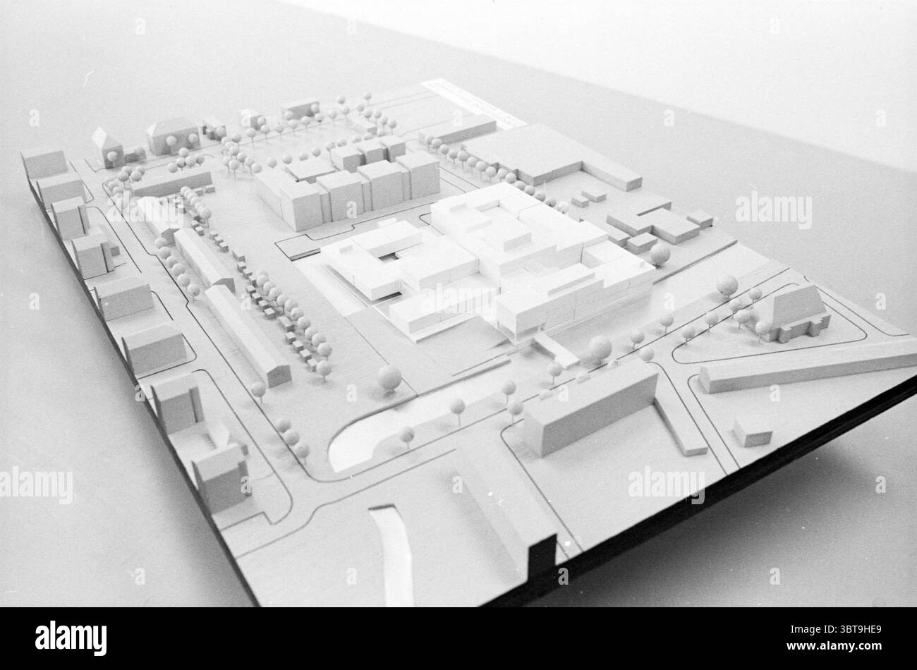 Plan de construction modèle Haarlem Agence des bâtiments gouvernementaux modèle Haarlem pays-Bas, Whizgle News, Dutch Desk, pays-Bas, 1950 - 2000 le 08-03-1988. L'image contient ces rubriques. La scène présente un modèle à l'échelle méticuleusement conçu d'un développement urbain. La palette de couleurs globale est monochrome, principalement dans les tons de blanc et de gris, ce qui souligne les lignes épurées et les formes géométriques des bâtiments et de la disposition. Au premier plan, plusieurs structures sont disposées de manière réfléchie, mettant en valeur des hauteurs et des conceptions variables. Ces bâtiments, bien que de couleur uniforme, présentent des différences Banque D'Images