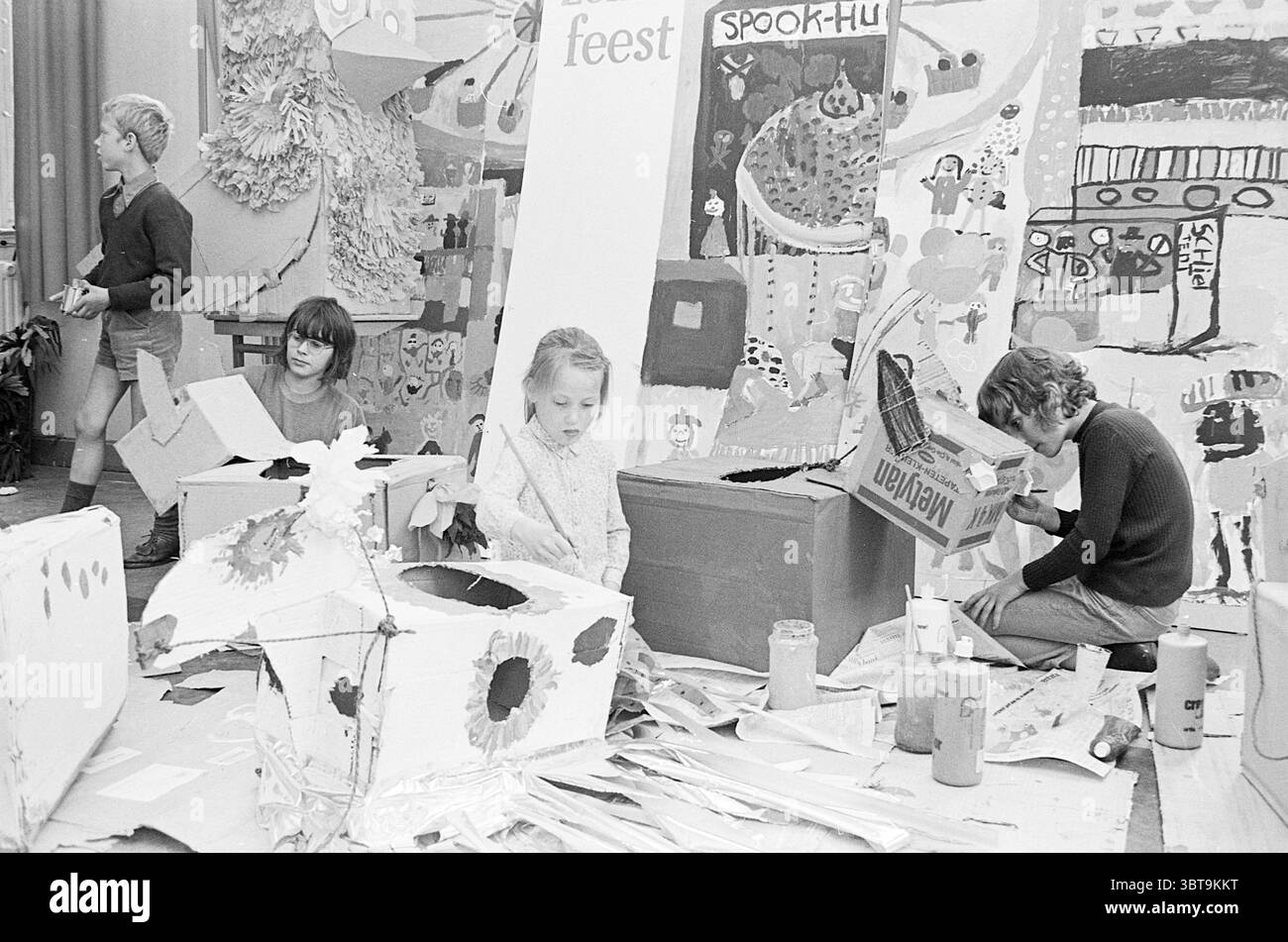 Enfants peinture enfants enfants maisons d'enfants enfants fête d'enfants enfants, Whizgle News, Dutch Desk, pays-Bas, 1950 - 2000 le 26-05-1971. Ces rubriques apparaissent dans l'image. La scène est animée de créativité et d'énergie jeune, dans une salle animée remplie de matériaux d'art et d'artisanat. En arrière-plan, une murale vibrante recouvre le mur, représentant une variété de personnages colorés et de paysages fantaisistes, avec des éclaboussures de teintes vives comme le rouge, le bleu, le vert et le jaune. Au premier plan, plusieurs enfants sont profondément engagés dans leurs efforts artistiques. Un garçon se tient à gauche, w Banque D'Images