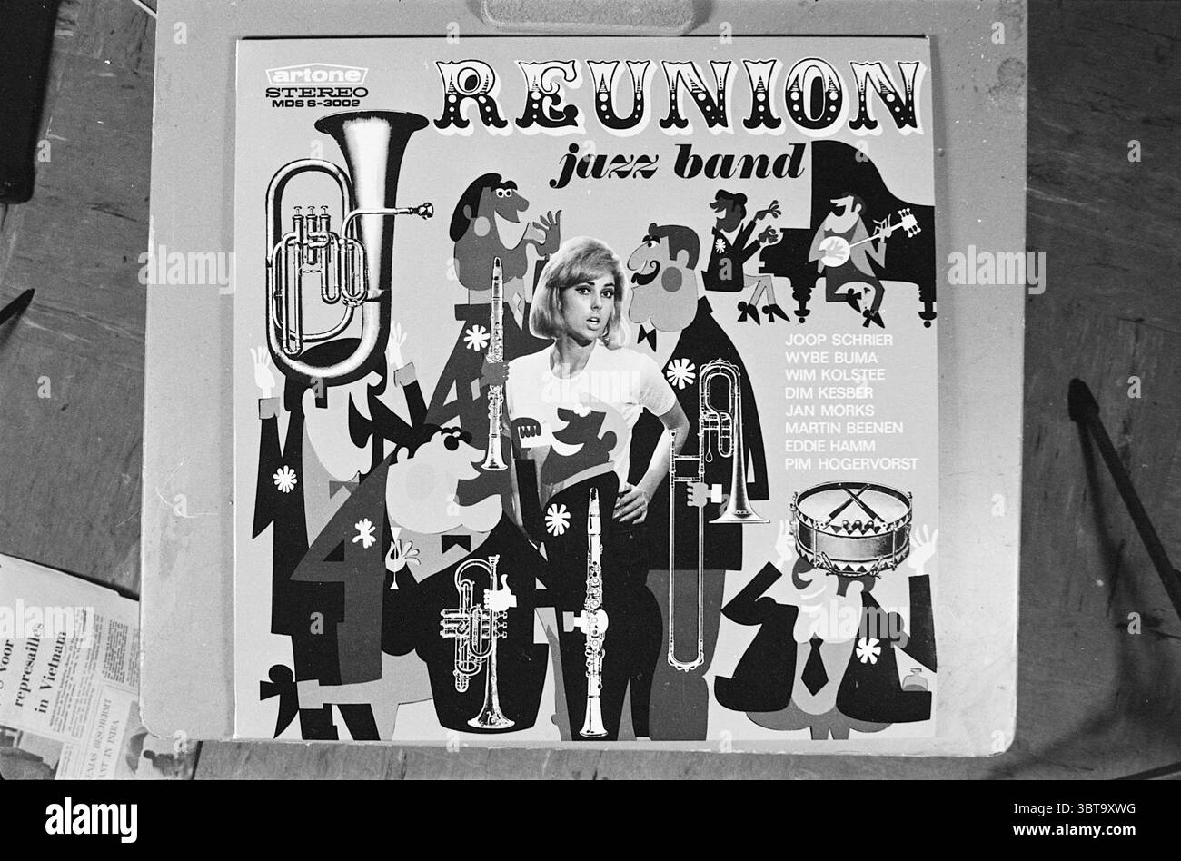 Groupe de jazz de RETROUVAILLES DE pochette de disque, Whizgle News, Dutch Desk, pays-Bas, 1950 - 2000 en 1967. Ces rubriques apparaissent dans l'image. Dans cette scène visuelle, une pochette d'album vibrante est présentée, dominée par un éventail de couleurs ludiques et audacieuses et de formes abstraites. L'arrière-plan présente un collage animé de figures et d'instruments qui suggèrent une atmosphère animée de groupe de jazz. Un point focal important est une illustration stylisée d'une femme aux cheveux blonds, frappant une pose dramatique qui respire l'énergie et le charisme. Elle semble faire partie de l'ensemble, nécessaire au rythme visuel de la scène. Surroundin Banque D'Images