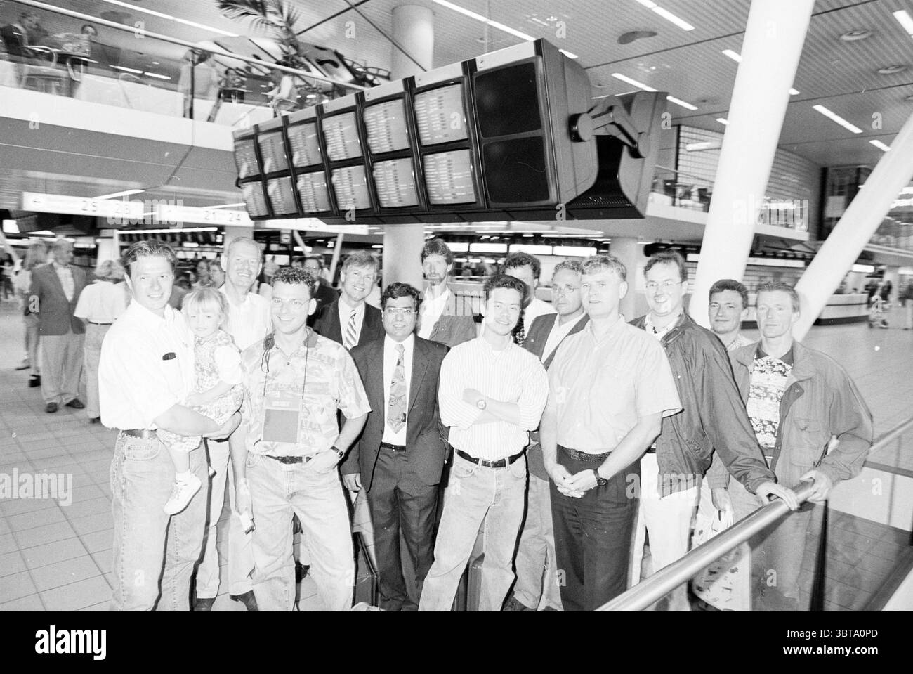 Ex-Fokkermensen mar. HSA Schiphol, Whizgle News, Dutch Desk, pays-Bas, 1950 - 2000 le 23-07-1996. L'image inclut ces rubriques. Dans un terminal d'aéroport animé, un groupe diversifié de personnes se réunit au premier plan, dégageant une atmosphère animée. Les individus varient en âge et en tenue vestimentaire, allant de vêtements décontractés à des tenues plus formelles, indiquant un mélange de raisons pour leur présence - certains semblent être des amis ou de la famille accueillant quelqu'un, tandis que d'autres peuvent être des collègues ou des associés d'affaires. Le cadre présente un design architectural moderne, caractérisé par des lignes épurées et un vaste spa ouvert Banque D'Images