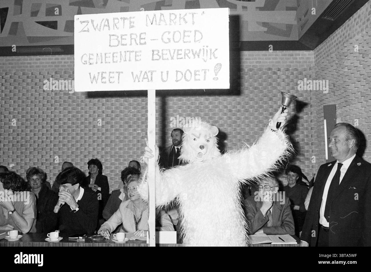 Démonstration pour le marché noir Beverwijk démonstration Beverwijk pays-Bas, Whizgle News, Dutch Desk, pays-Bas, 1950 - 2000 le 10-03-1983. Voici les rubriques de l'image. Dans un espace de rassemblement caractérisé par un cadre quelque peu formel, une figure dans un costume blanc à fourrure surdimensionné se distingue en évidence, tenant un grand signe en hauteur. Le costume ressemble à un animal, apportant une qualité surréaliste et fantaisiste à la scène. La tête du personnage est ornée d'un masque ou d'une tête rembourrée, renforçant le ton ludique mais sérieux de la manifestation. Autour de la figure, plusieurs personnes sont en mer Banque D'Images