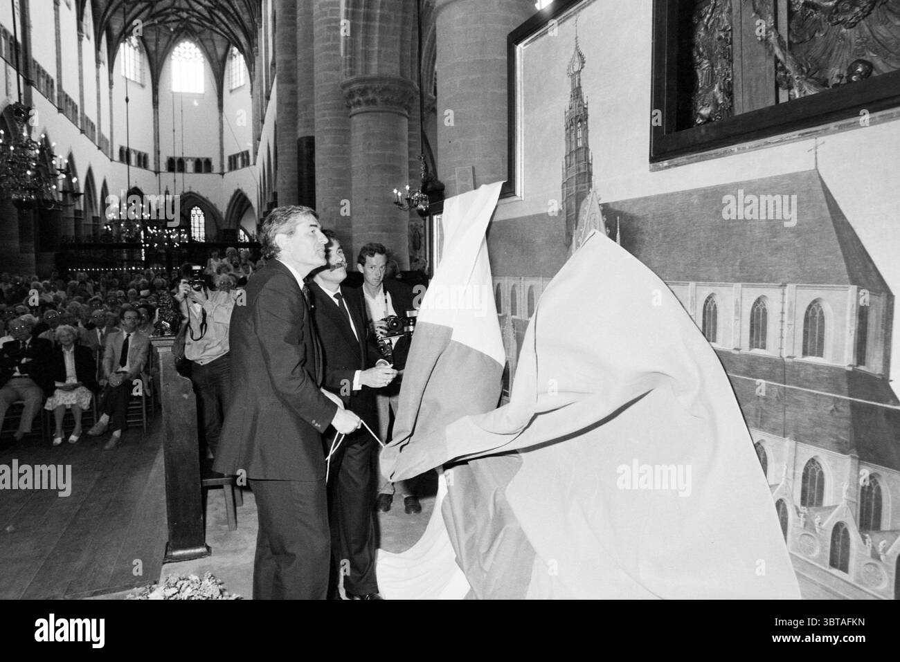 Ouverture de l'hôtel de ville par le ministre Lubbers dévoilement de la peinture de la grande église Haarlem ville ouverte protester contre les centres communautaires pendant la journée de la ville ouverte de Haarlem cours pour enfants dans le journal avec le ministre Lubbers Haarlem enfants enfants maisons d'enfants fête d'enfants enfants révélations Haarlem pays-Bas, Whizgle News, Dutch Desk, pays-Bas, 1950 - 2000 le 21-06-1986. Ces rubriques apparaissent dans l'image. La scène capture un moment important dans un intérieur grandiose et caverneux d'un bâtiment, probablement une cathédrale ou un hall historique, caractérisé par d'imposantes colonnes de pierre et des arches complexes. T Banque D'Images