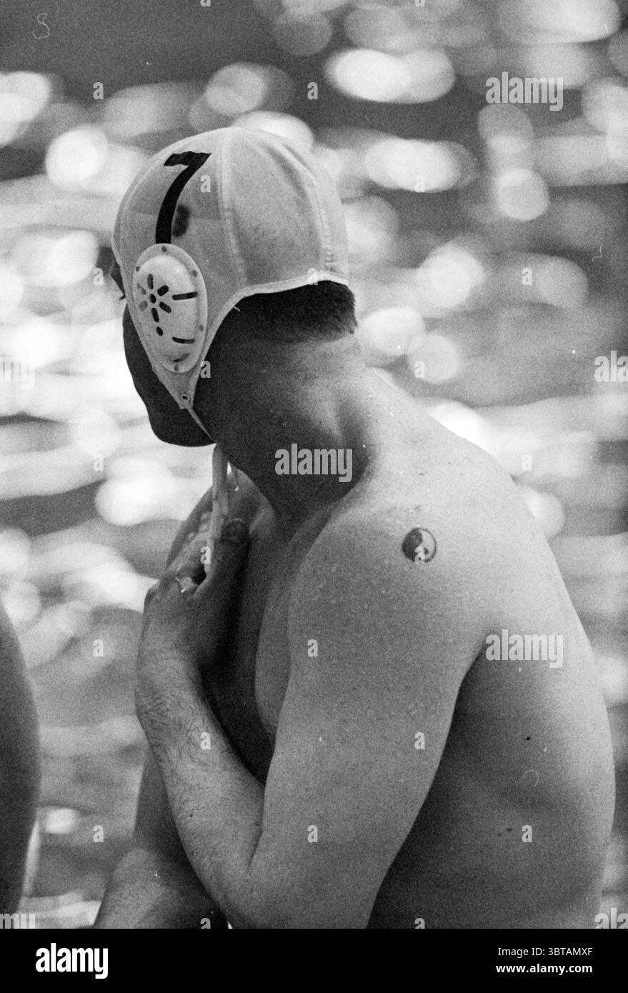 NVA - Rapido, Whizgle News, Dutch Desk, pays-Bas, 1950 - 2000 le 07-04-1995. Ces rubriques sont illustrées dans l'image. La scène capture une vue rapprochée d'un joueur de water-polo, exposant les nuances du moment. L’individu est positionné dos tourné vers l’observateur, présentant un physique musclé accentué par des gouttelettes d’eau scintillant sur sa peau. Ils portent une casquette blanche ornée d'un chiffre distinctif '7' et de protections auditives, les deux faisant allusion à leur rôle dans le sport. Un petit tatouage yin-yang est visible sur leur épaule, ajoutant une touche personnelle à la scène. Le paramètre Banque D'Images NVA - Rapido, Whizgle News, Dutch Desk, pays-Bas, 1950 - 2000 le 07-04-1995. Ces rubriques sont illustrées dans l'image. La scène capture une vue rapprochée d'un joueur de water-polo, exposant les nuances du moment. L’individu est positionné dos tourné vers l’observateur, présentant un physique musclé accentué par des gouttelettes d’eau scintillant sur sa peau. Ils portent une casquette blanche ornée d'un chiffre distinctif '7' et de protections auditives, les deux faisant allusion à leur rôle dans le sport. Un petit tatouage yin-yang est visible sur leur épaule, ajoutant une touche personnelle à la scène. Le paramètre Banque D'Images