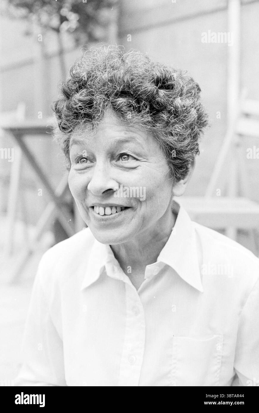 Poètes : Judith Herzberg Hannie Michaelis Jean Pierre Rawie Wouter Kotte Wouter Kotte et ton Luiting hans VL ek Bert Sliggers Neeltje Maria min Joyce and Co lecture et conférences, Whizgle News, Dutch Desk, pays-Bas, 1950 - 2000 on 09-06-1979. Ces rubriques apparaissent dans l'image. La scène capture une femme âgée avec des cheveux bouclés et vibrants qui encadrent son visage. Son expression est chaleureuse et accueillante, caractérisée par un large sourire qui rayonne de joie et d’enthousiasme. Son teint a une lueur naturelle, et ses yeux brillants semblent scintiller de gentillesse. Elle est habillée d'un shir à col clair Banque D'Images