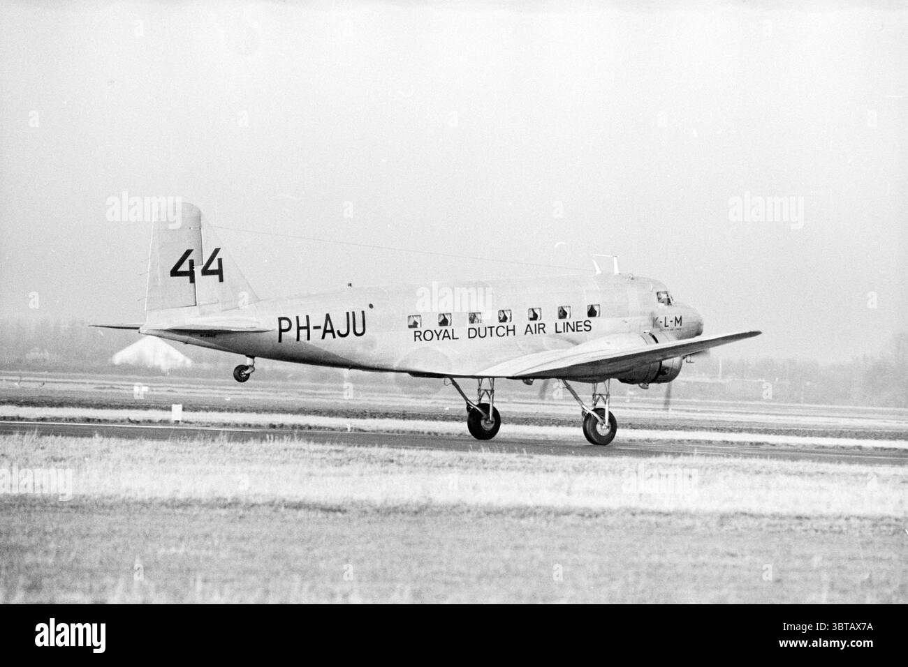 Départ du 'de Uiver' en raison du 50ème anniversaire du vol Londres - Melbourne Airplanes Schiphol Haarlemmermeer, Whizgle News, Dutch Desk, pays-Bas, 1950 - 2000 le 18-12-1983. L'image contient ces rubriques. La scène montre un avion vintage, bien en vue alors qu'il se déplace sur une piste. L'avion présente un corps élancé et allongé avec une structure de queue distincte, ornée d'un numéro d'immatriculation et des mots « Royal Dutch Air Lines ». Sa surface est en grande partie métallique, reflétant des tons sourds de gris et d'argent. Les ailes de l’avion s’étendent vers l’extérieur, les moteurs étant montés sous t Banque D'Images