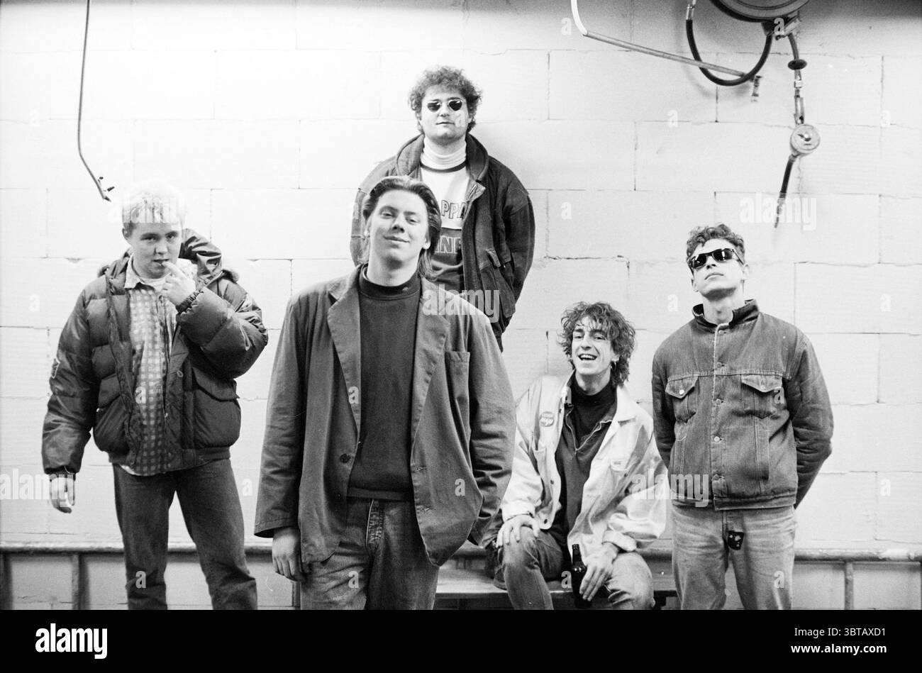 Ben van Leeuwen Band Music, Whizgle News, Dutch Desk, pays-Bas, 1950 - 2000 sur 23-11-1988. Ces rubriques apparaissent dans l'image. La scène met en scène un groupe de cinq individus positionnés dans un arrangement décontracté, créant un sentiment de camaraderie. Le fond est un mur plat texturé peint dans une couleur claire, qui contraste avec les vêtements plus sombres du groupe. Les individus affichent une variété de styles, reflétant un mélange de mode décontracté et légèrement dynamique. Une personne à l'extrême gauche porte une veste bouffante sur une chemise à carreaux, montrant une ambiance décontractée. A côté de lui, un autre ind Banque D'Images