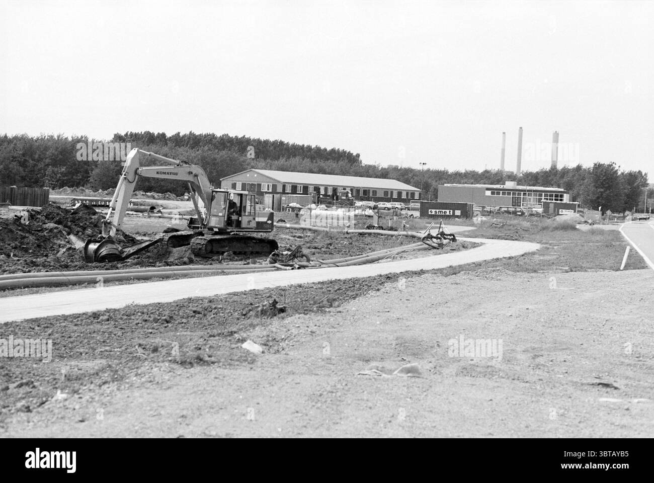 Aperçu des préparatifs du Wijkertunnel, Whizgle News, Dutch Desk, pays-Bas, 1950 - 2000 le 31-05-1993. Ce sont les éléments de l'image. La scène présente une grande zone de construction caractérisée par la terre en cours d'excavation et de transformation. Au premier plan, une excavatrice grise est bien en vue, son bras étendu alors qu'elle creuse dans le sol brun. Ce véhicule est détaillé avec différentes nuances de gris et de vert, montrant des signes d'utilisation. À gauche, le sol est inégal, révélant des sections de terre fraîchement retournée éparpillées de roches et de petits débris. Des tas de terre semi-circulaires se trouvent Banque D'Images