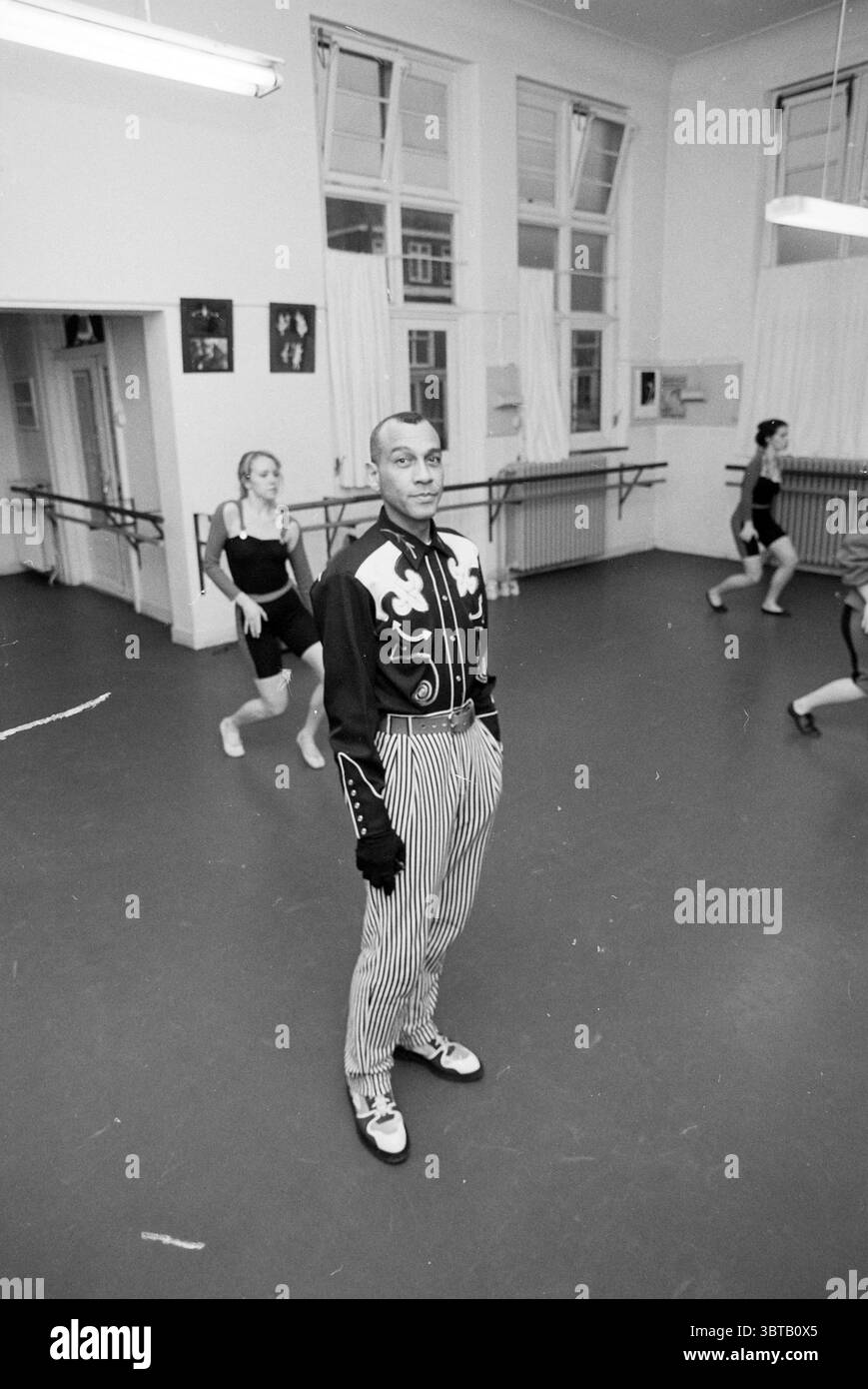 Rep. Dance studio E. IJs Egelantier, Whizgle News, Dutch Desk, pays-Bas, 1950 - 2000 le 13-04-1992. L'image inclut ces rubriques. La scène se déroule dans un studio de danse spacieux, caractérisé par des planchers en bois poli et de grandes fenêtres qui permettent à la lumière naturelle d'inonder la pièce. Les murs sont peints dans une couleur discrète, ornés de quelques photographies encadrées qui font allusion à des performances passées ou à l'histoire de la danse. Au premier plan, une personne positionnée au centre se tient confiante. Cette personne est habillée dans une tenue saisissante avec une veste à motifs avec des motifs blancs et des rayures foncées et audacieuses Banque D'Images