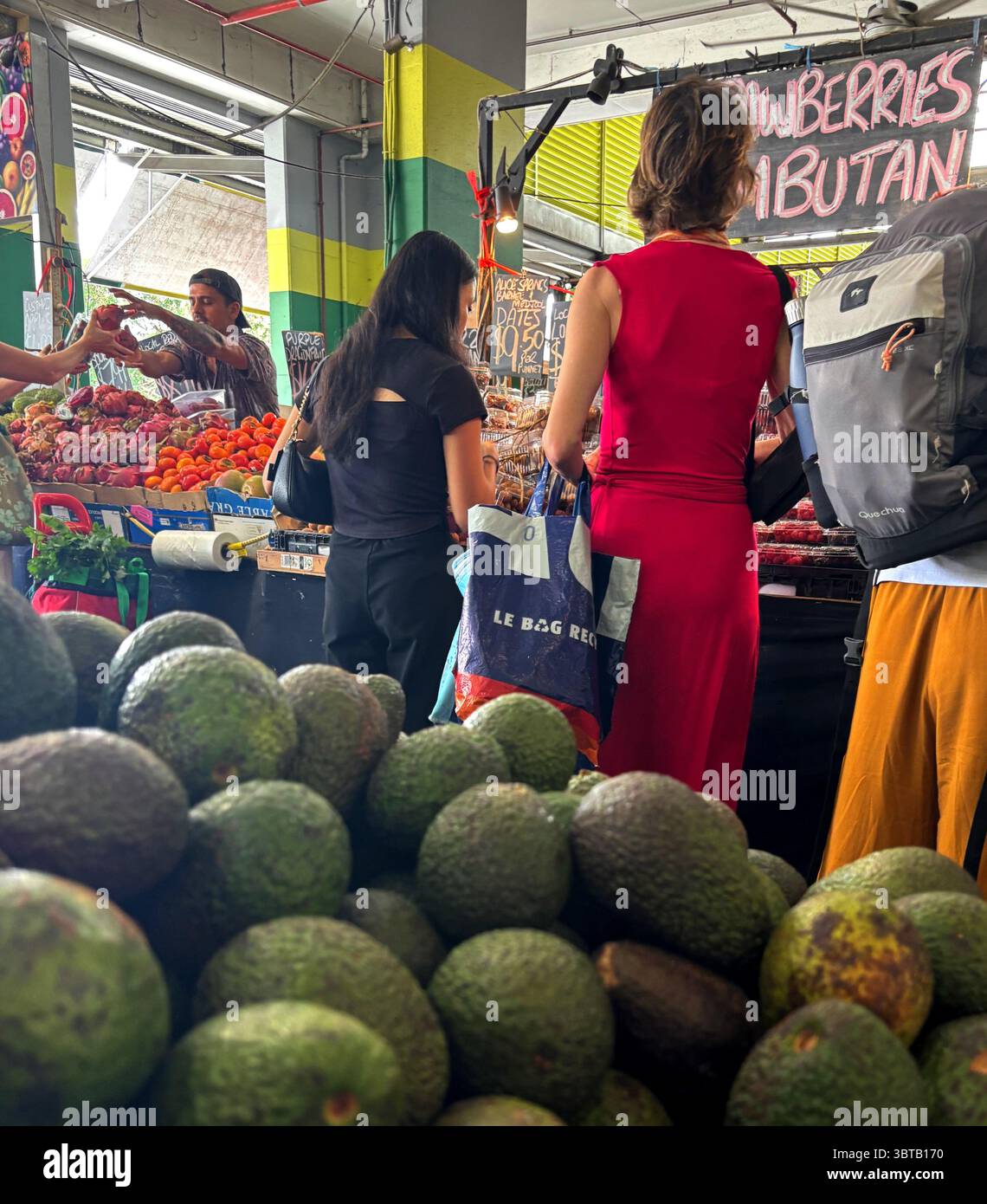 Les gens font du shopping parmi des tas d'avocats et d'autres fruits tropicaux, Rustys Markets, Cairns, Queensland, Australie. Pas DE MR ou PR - Image de stock capturée avec un smartphone