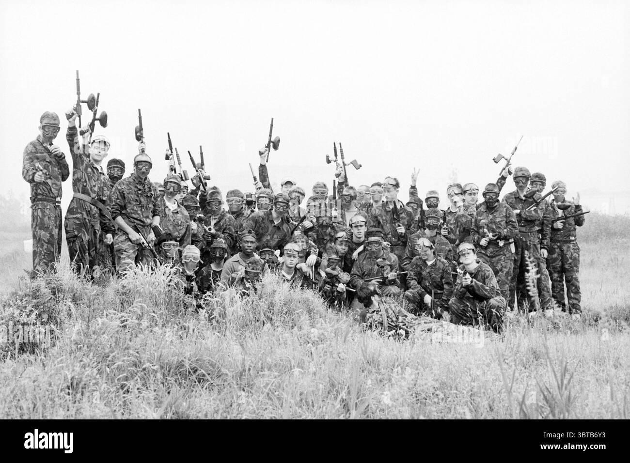 Paintball Shooting Sloterdijk, Whizgle News, Dutch Desk, pays-Bas, 1950 - 2000 sur 06-06-1992. Voici les rubriques de l'image. La scène montre un grand groupe d'individus, tous vêtus d'un équipement de camouflage de style militaire. Leur tenue vestimentaire suggère un thème militaire ou tactique, avec différentes nuances de vert et de brun se mélangeant parfaitement dans un environnement brumeux ou brumeux. Le groupe est positionné dans une formation semi-circulaire, avec certains individus debout bien en vue à l'avant et d'autres accroupis derrière. Les expressions des membres du groupe vont de ludique à sérieuse, capturant un mix o Banque D'Images
