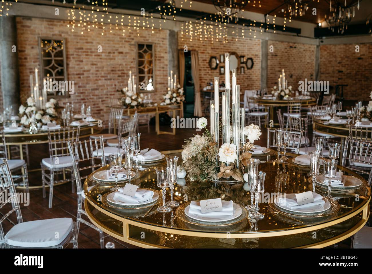 Réception de mariage élégante avec tables éclairées aux chandelles et pièces maîtresses florales dans un cadre rustique. la configuration met en valeur la sophistication et le charme avec exq Banque D'Images