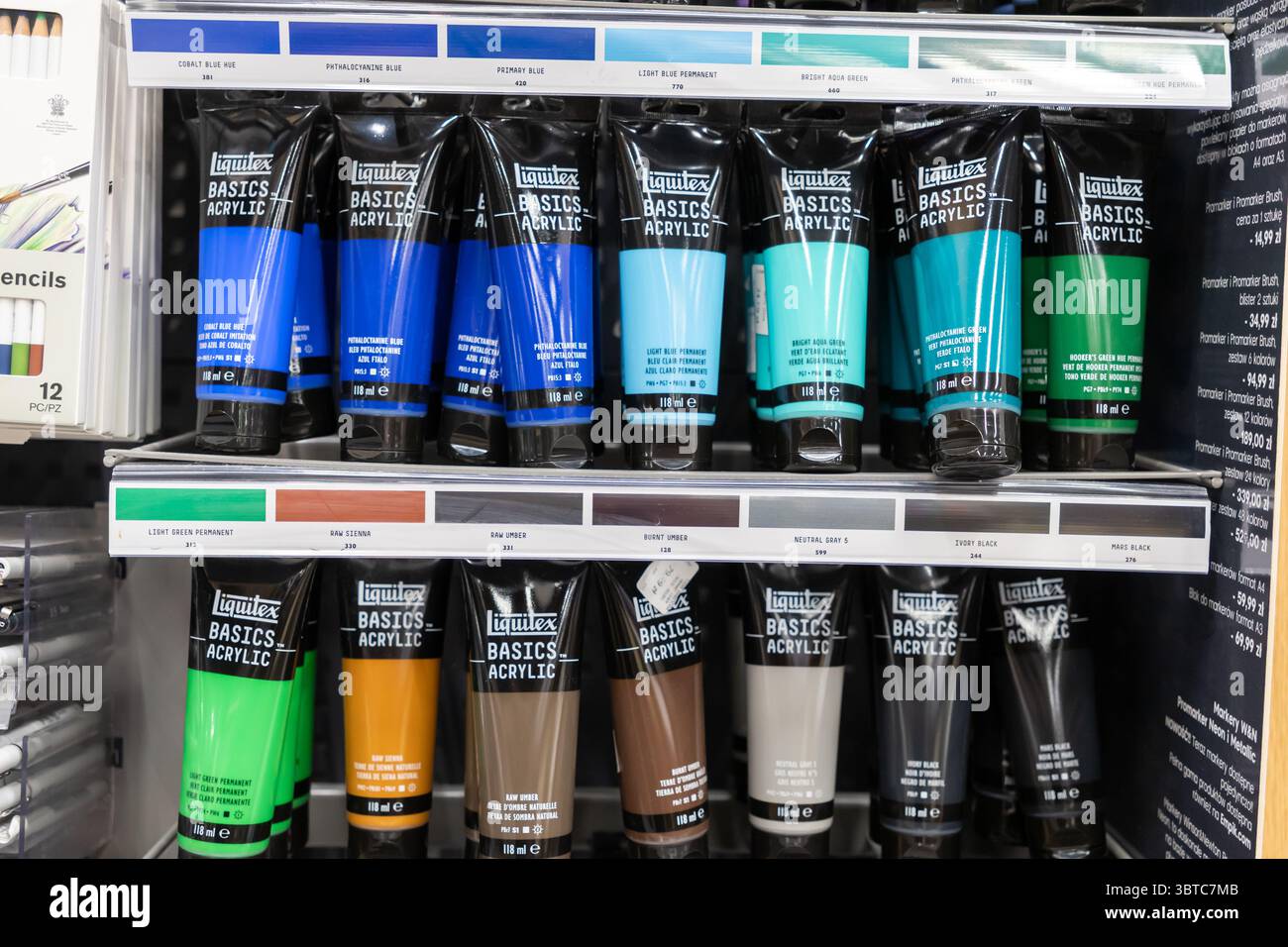 Poznan, Pologne - 30 juin 2025 : les tubes de peinture ACRYLIQUE colorés Liquitex BASICS, y compris les bleus et les verts, sont soigneusement disposés sur les étagères de vente au détail pour AS Banque D'Images
