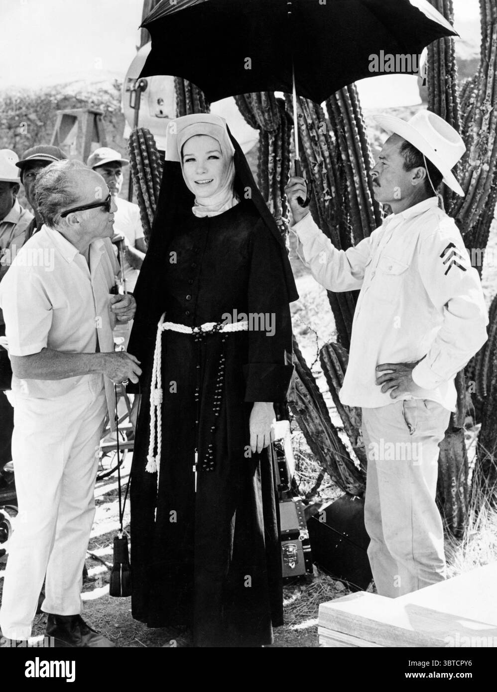 Fév 1969 - Cocoyoc, Mexique - SHIRLEY MACLAINE, vêtue d'un costume de nonne, sourit pendant une pause dans le tournage de 'deux mules pour soeur Sara' tandis qu'un homme la masque avec un parapluie. (Crédit image : © Keystone Press Agency/Keystone USA via ZUMAPRESS.com) Banque D'Images
