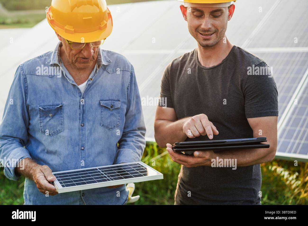 Ingénieurs travaillant à l'usine de panneaux solaires en plein air - photovoltaïque, énergie verte renouvelable et concept environnemental - principal accent sur la tablette Banque D'Images