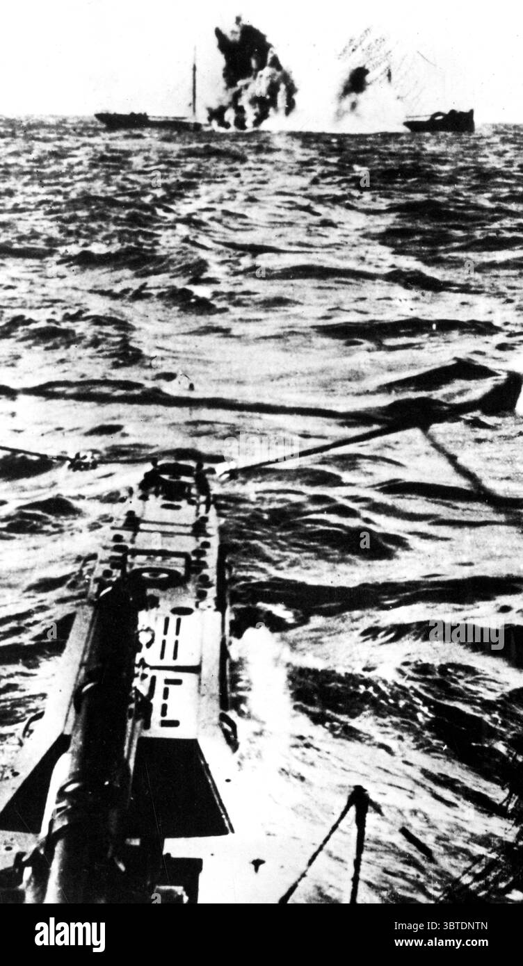 Avec un éclair de flamme un cargo explose , frappé mort au milieu du navire par une torpille . Les torpilles voyageaient à environ 40 nœuds et devaient être dirigées devant un navire en mouvement. Ici, une nappe à la surface marque le parcours mortel de la torpille. Au début, les capitaines de bateaux ont ordonné aux victimes d'abandonner les navires, mais lorsque des canons ont été mis sur des marchands, ils ont été coulés sans avertissement Banque D'Images