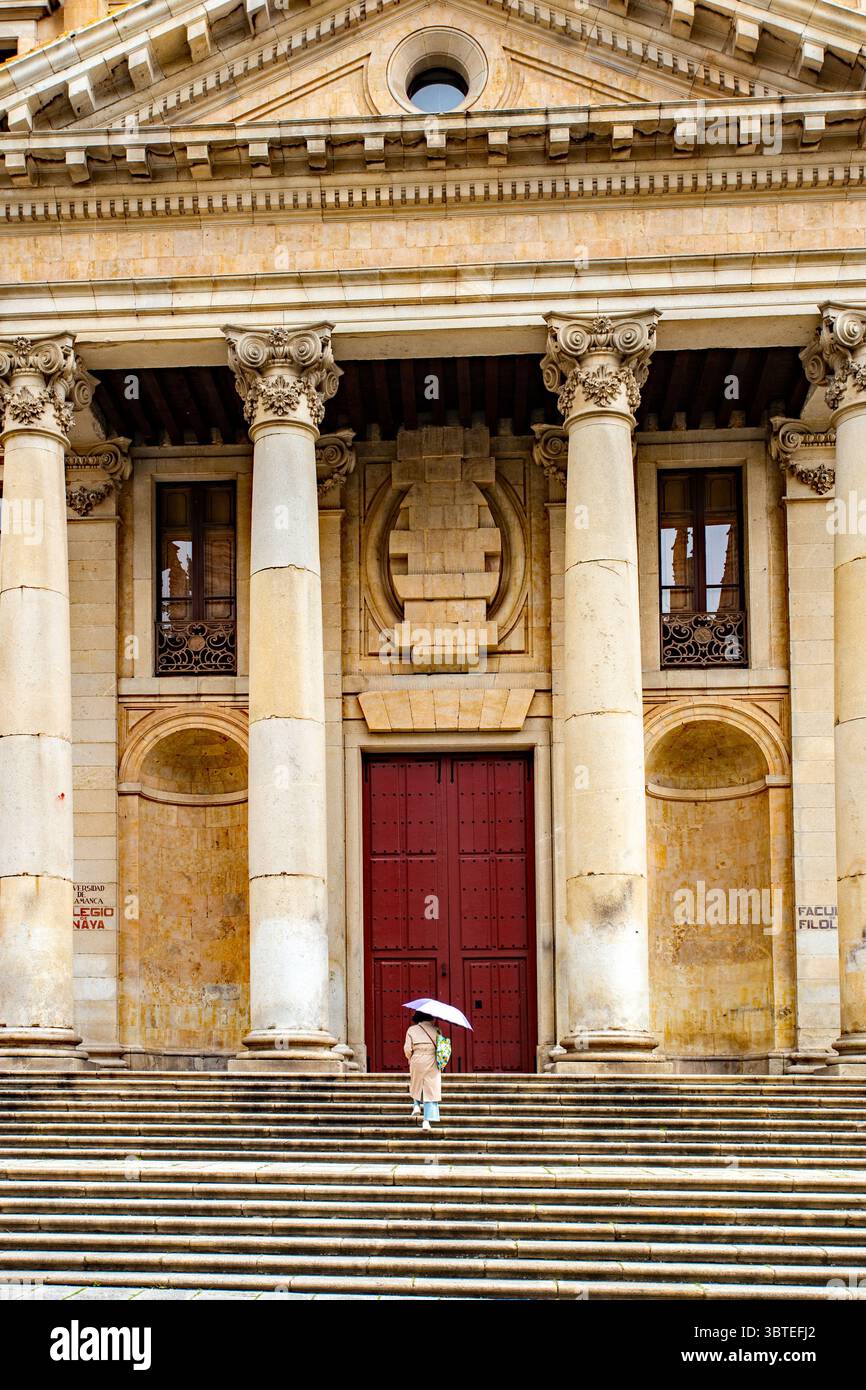 Femme avec parasol sur les marches du Palacio de Anaya à Salamanque, Espagne siège de la Faculté de Philologie de l'Université de Salamanque. Banque D'Images