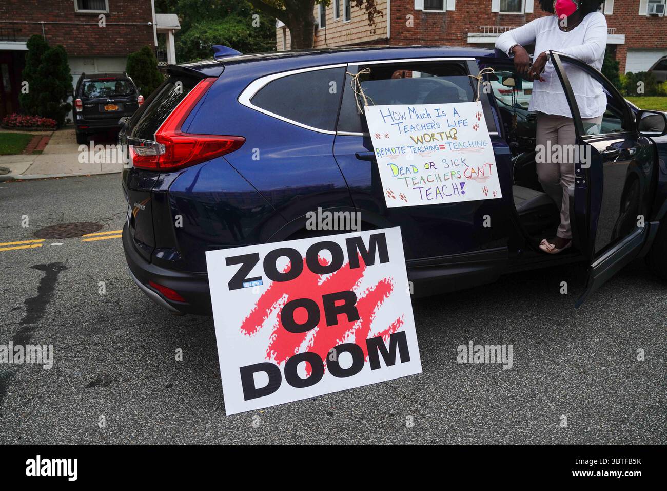 17 septembre 2020, New York, États-Unis : un étudiant du lycée Benjamin N. Cardozo d'Oakland Gardens, Queens, New York pose sur une voiture avec des pancartes lors d'une manifestation contre l'apprentissage en personne alors que les enseignants soulèvent de nouvelles préoccupations sur la préparation des écoles contre le COVID-19 ..le maire de New York Bill de Blasio et le chancelier des écoles Richard Carranza ont dévoilé leur plan ''Blended Learning'' pour les 1,1 millions d'élèves des écoles publiques de la ville. (Crédit image : © John Nacion/SOPA images via ZUMA Wire) Banque D'Images