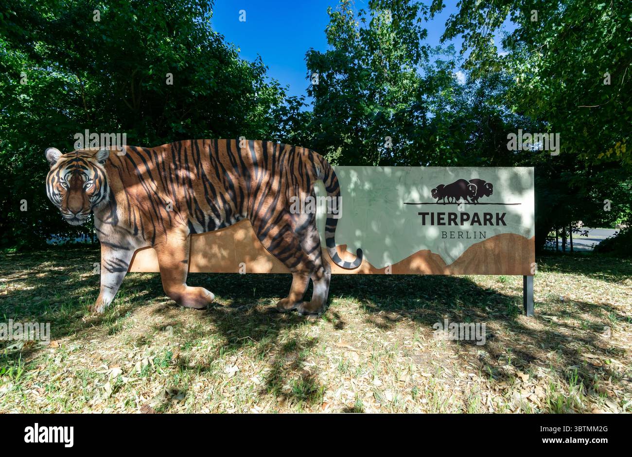Exposition créative en forme de tigre faisant la promotion du Tierpark Berlin dans un cadre extérieur ombragé entouré de verdure. Banque D'Images