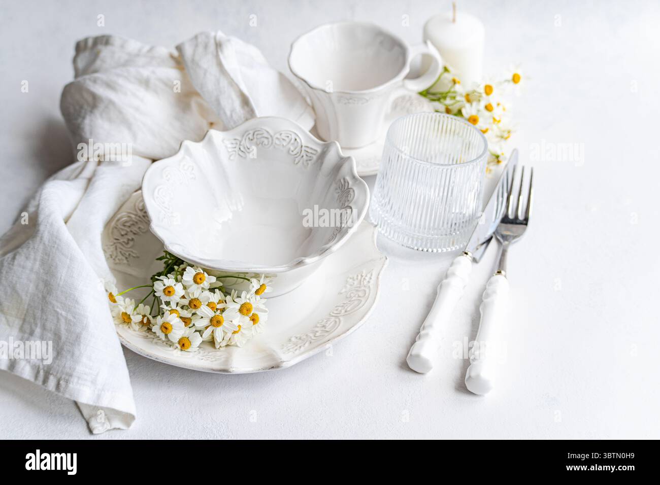 Elégante place blanche sur une table décorée de marguerites Banque D'Images