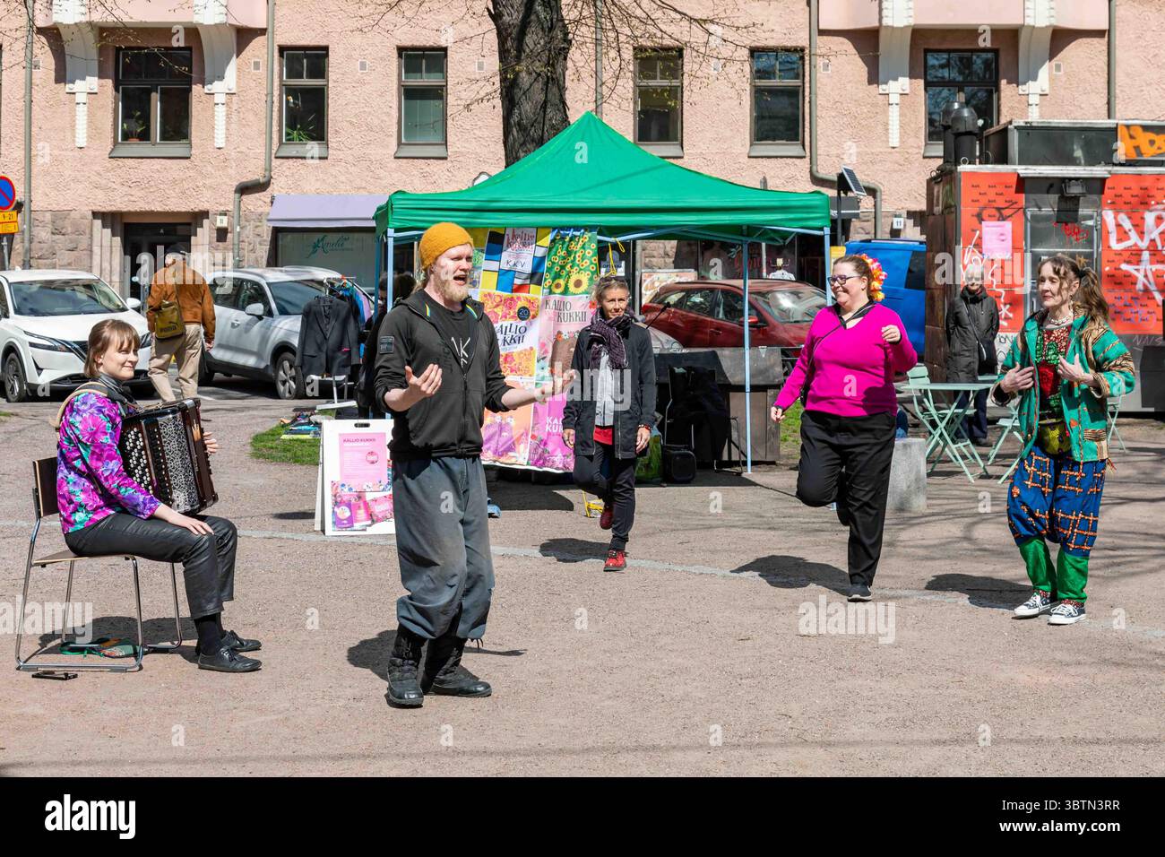 Les locaux avec l'artiste de danse Arttu Peltoniemi au festival communautaire Kallio Kukkii 2025 à Karhupuisto, Kallio, Helsinki Banque D'Images