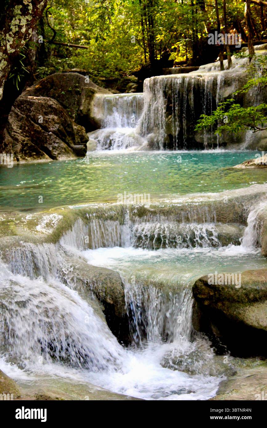 Cascade à plusieurs niveaux se jette dans des piscines turquoise dans le parc national d'Erawan, en Thaïlande, entouré d'une forêt luxuriante dans un cadre naturel serein Banque D'Images