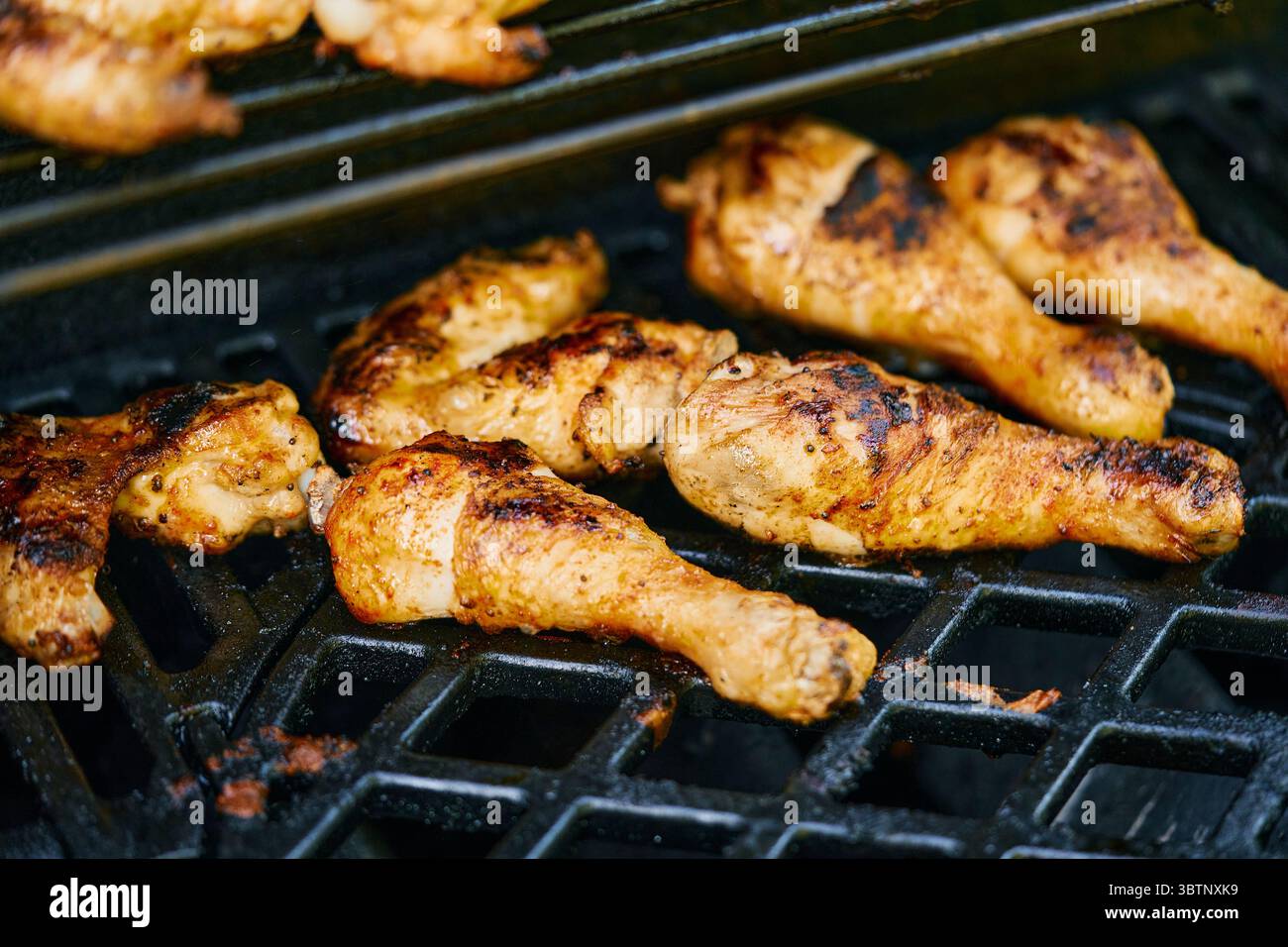 Pilons de poulet grillant sur le barbecue Banque D'Images