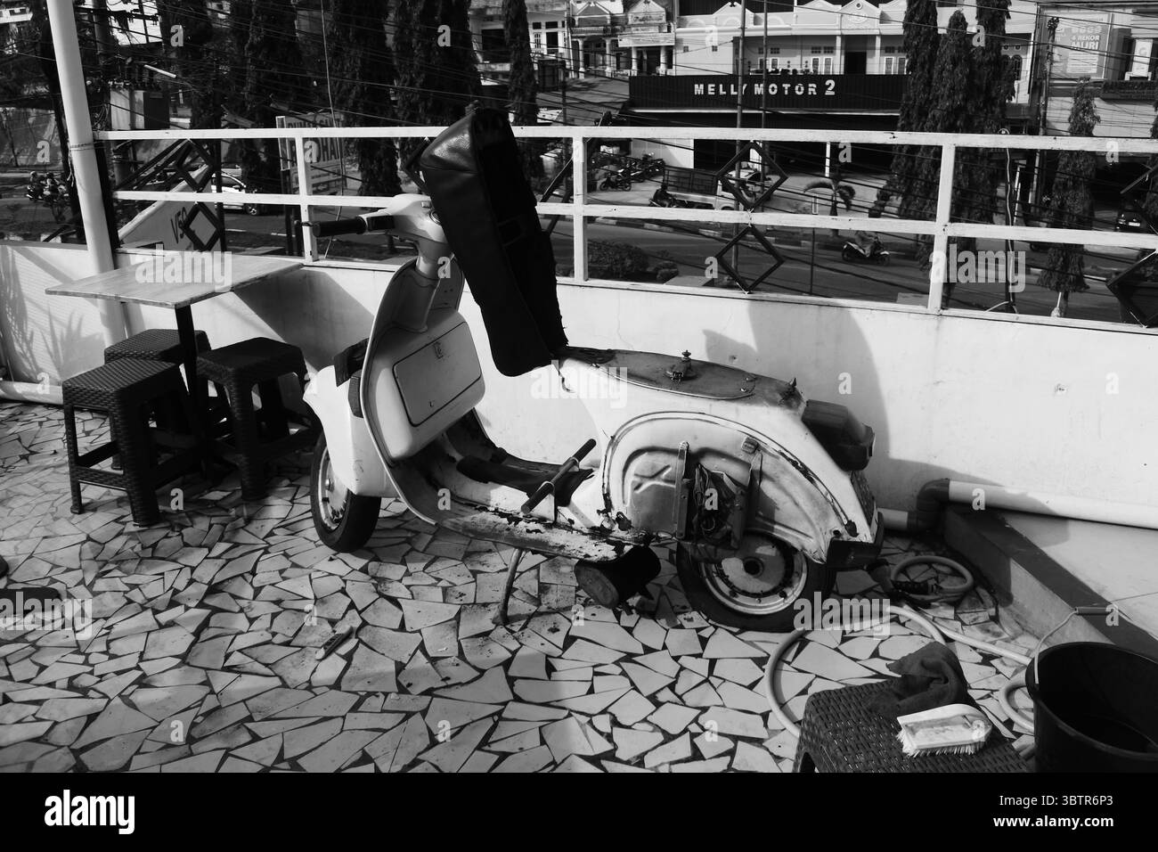 Scooter vintage garé à l'extérieur avec décor rustique en photo noir et blanc Banque D'Images