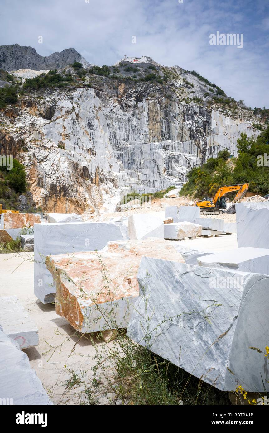 Excavatrice à la carrière de marbre dans les Alpes Apuanes produisant le célèbre marbre de Carrare, connu pour ses veines blanches et grises dans la province de Massa et Carra Banque D'Images