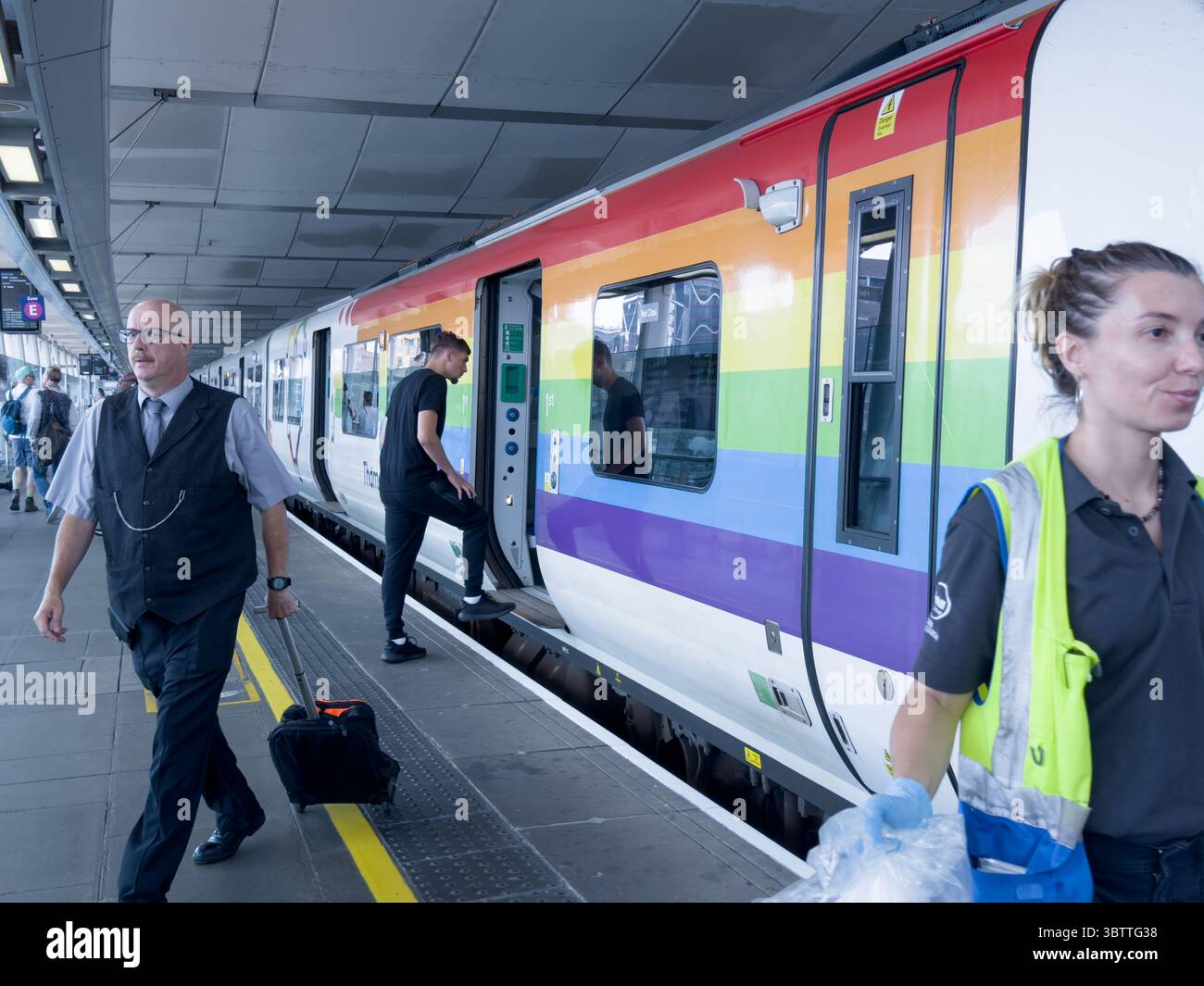 La voiture Thameslink colorée arc-en-ciel célèbre le mois de la fierté avec les passagers qui montent et descendent à la plate-forme, Londres Banque D'Images