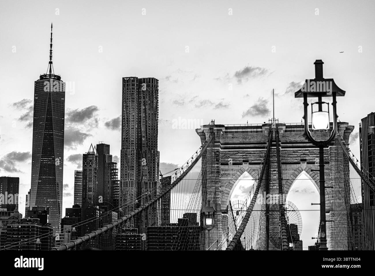 Coucher de soleil sur le pont de Brooklyn le soir et la nuit tombent en gros plan sur les câbles de promenade et les arches en pierre dans Lower Manhattan New York City Banque D'Images