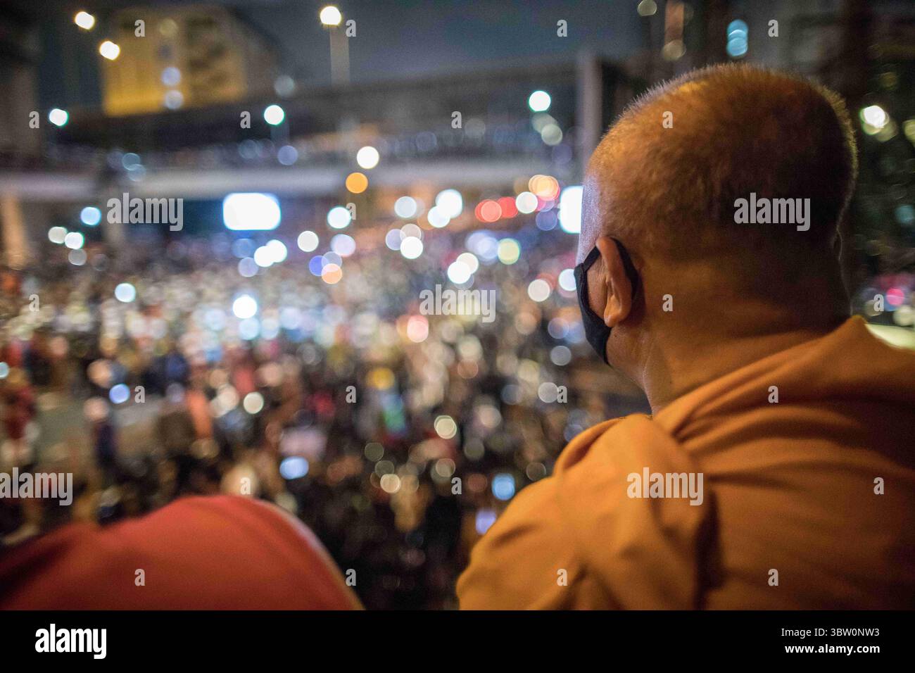 21 octobre 2020, Bangkok, Thaïlande : un moine bouddhiste thaïlandais regardant la foule de manifestants pro-démocratie lors d'une manifestation antigouvernementale dans la capitale thaïlandaise. Des milliers de manifestants pro-démocratie sont descendus dans les rues au Monument de la victoire pour exiger la démission du premier ministre thaïlandais et la réforme de la monarchie pour le septième jour après un état sévère de emergencyâ€˜de â€™ déclaré par le premier ministre Prayut Chan-o-cha. Les manifestants ont défilé du Monument de la victoire au Government House et ont remis une lettre au premier ministre Prayut Chan-o-cha lui demandant de démissionner avant 3 jours. Th Banque D'Images