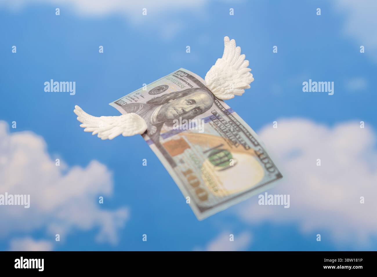 Un billet de cent dollars avec de petites ailes blanches. L'argent s'envole, concept de perte financière. Banque D'Images
