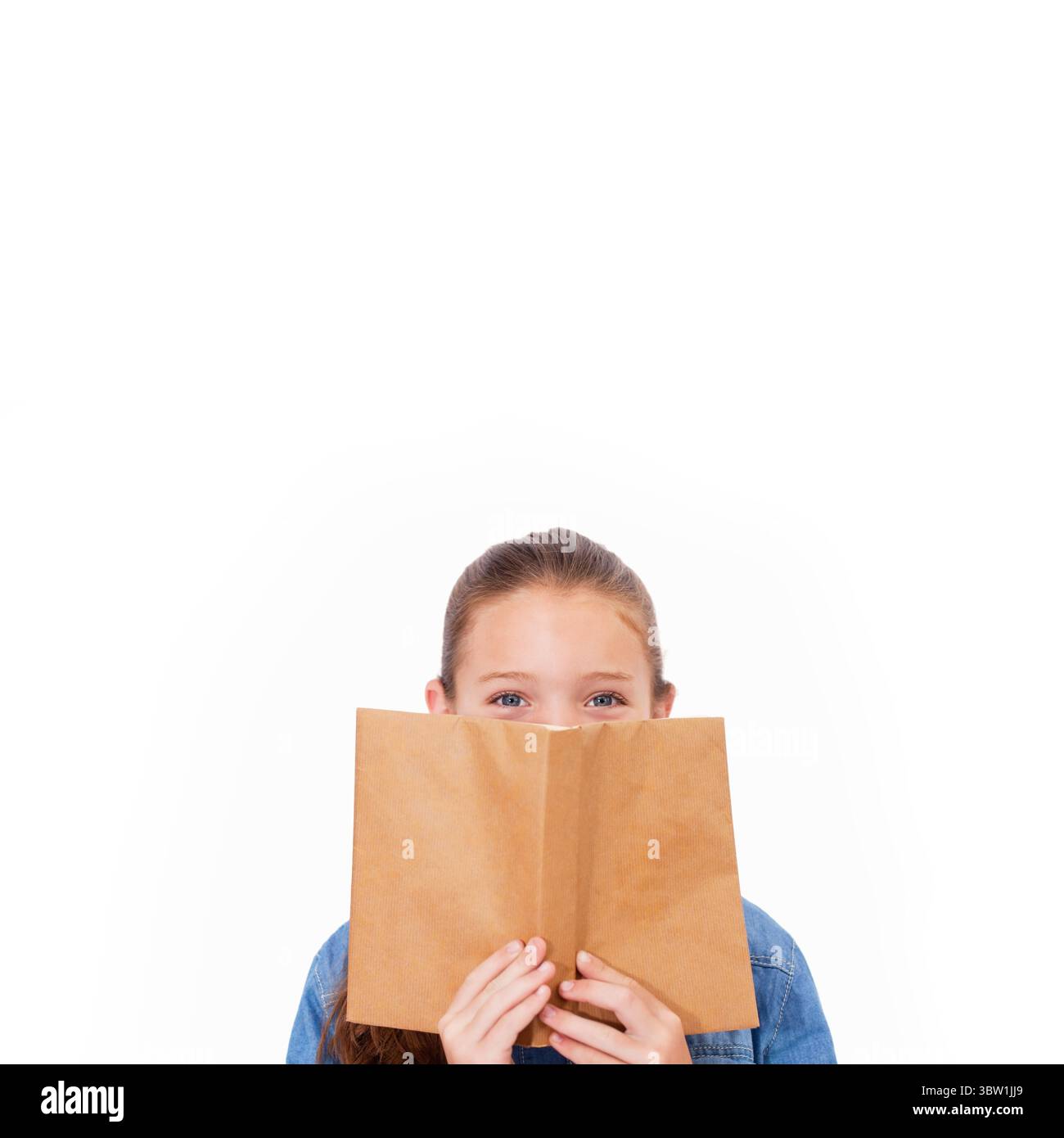 la fille tient le livre de poche ouvert sur le visage contre fond blanc dans la conception plate, espace de copie Banque D'Images