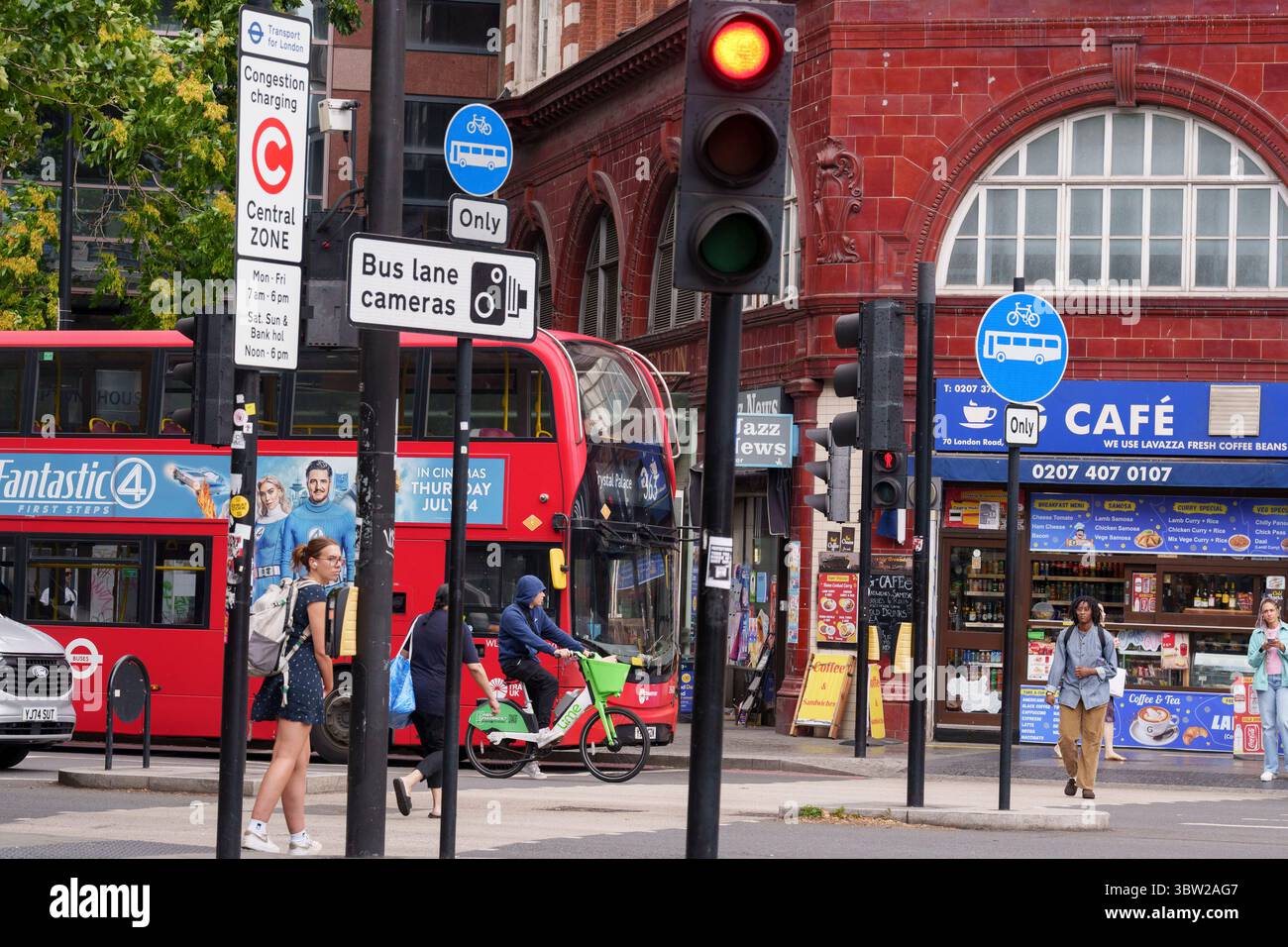 Trafic de bus et piétons à l'un des nombreux passages à niveau à l'intersection animée Elephant and Castle, le 15 juillet 2025, à Londres, en Angleterre. Banque D'Images